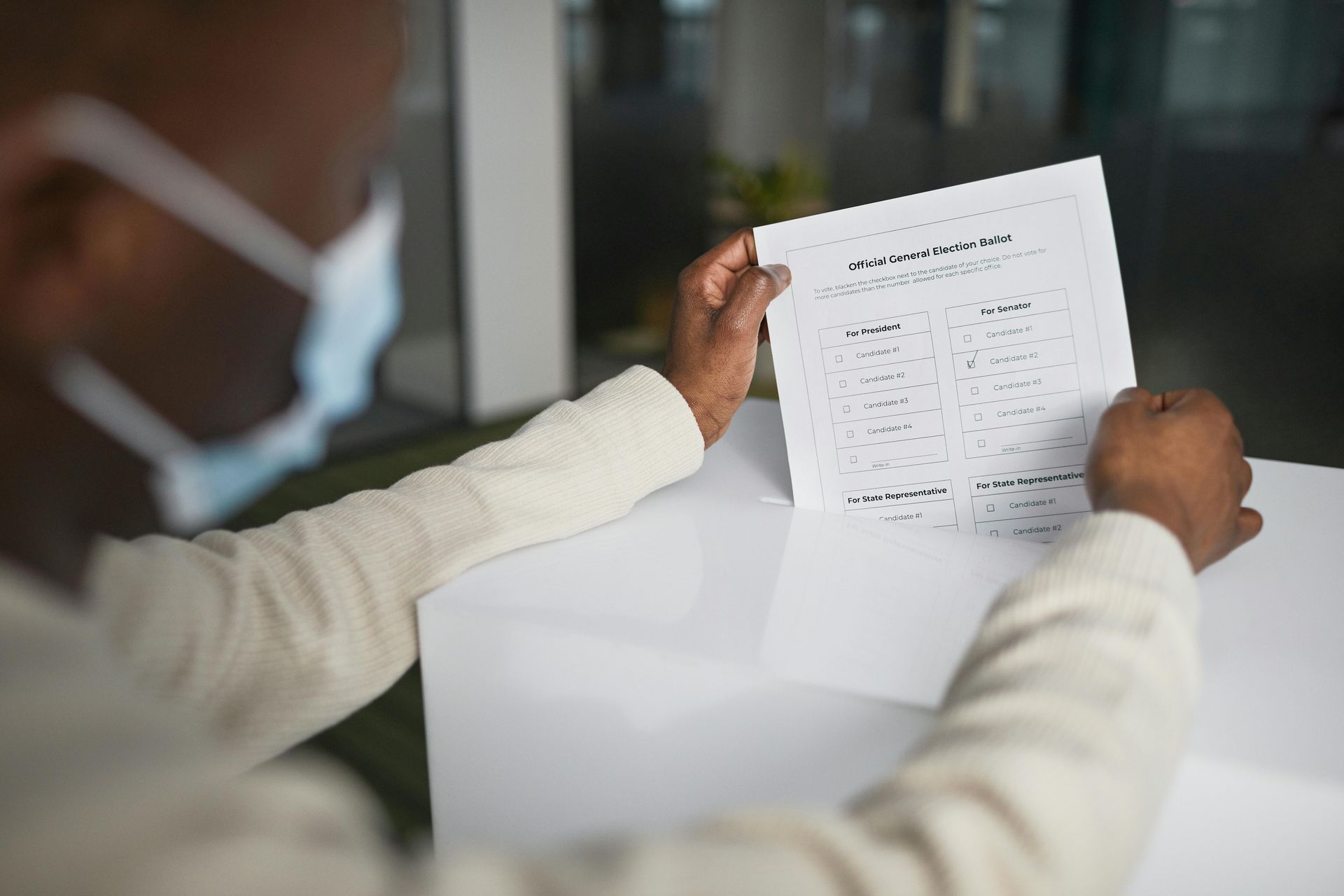 A man wearing a mask is reading a piece of paper.