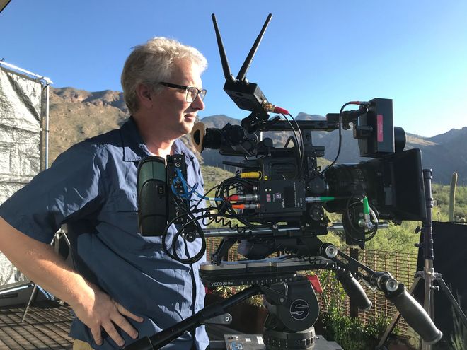 a man looks into a viewfinder of a big camera