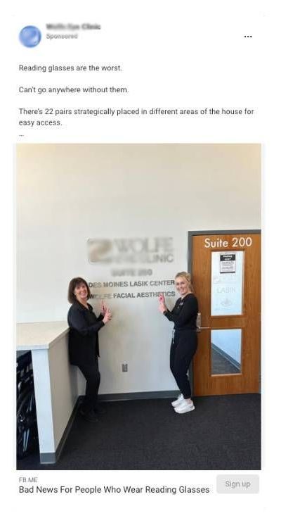 Two healthcare workers are standing next to each other in front of a door.