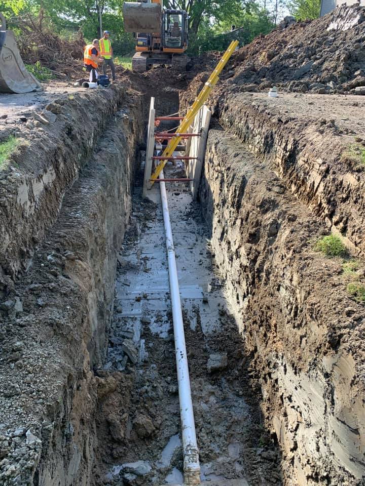 Un tuyau est en cours d'installation dans une tranchée.