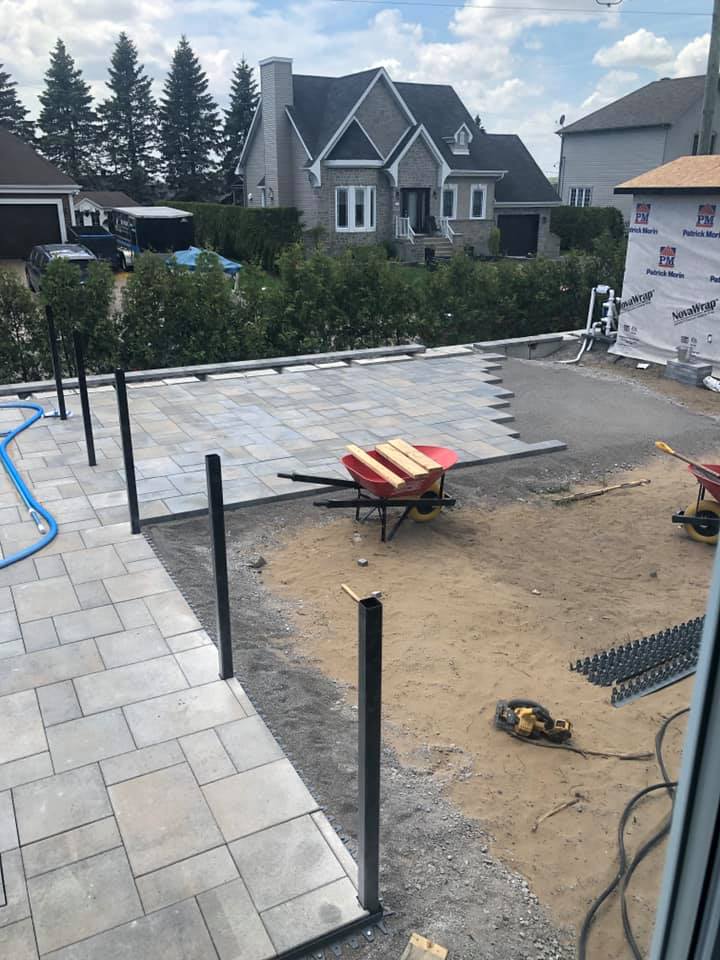 Une brouette est posée sur le sol devant une maison.