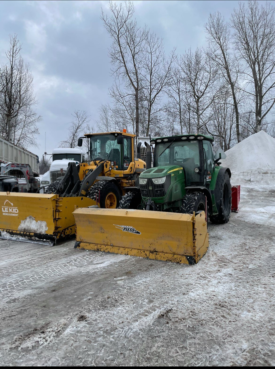Deux chasse-neige sont garés l un à côté de l autre dans un parking.
