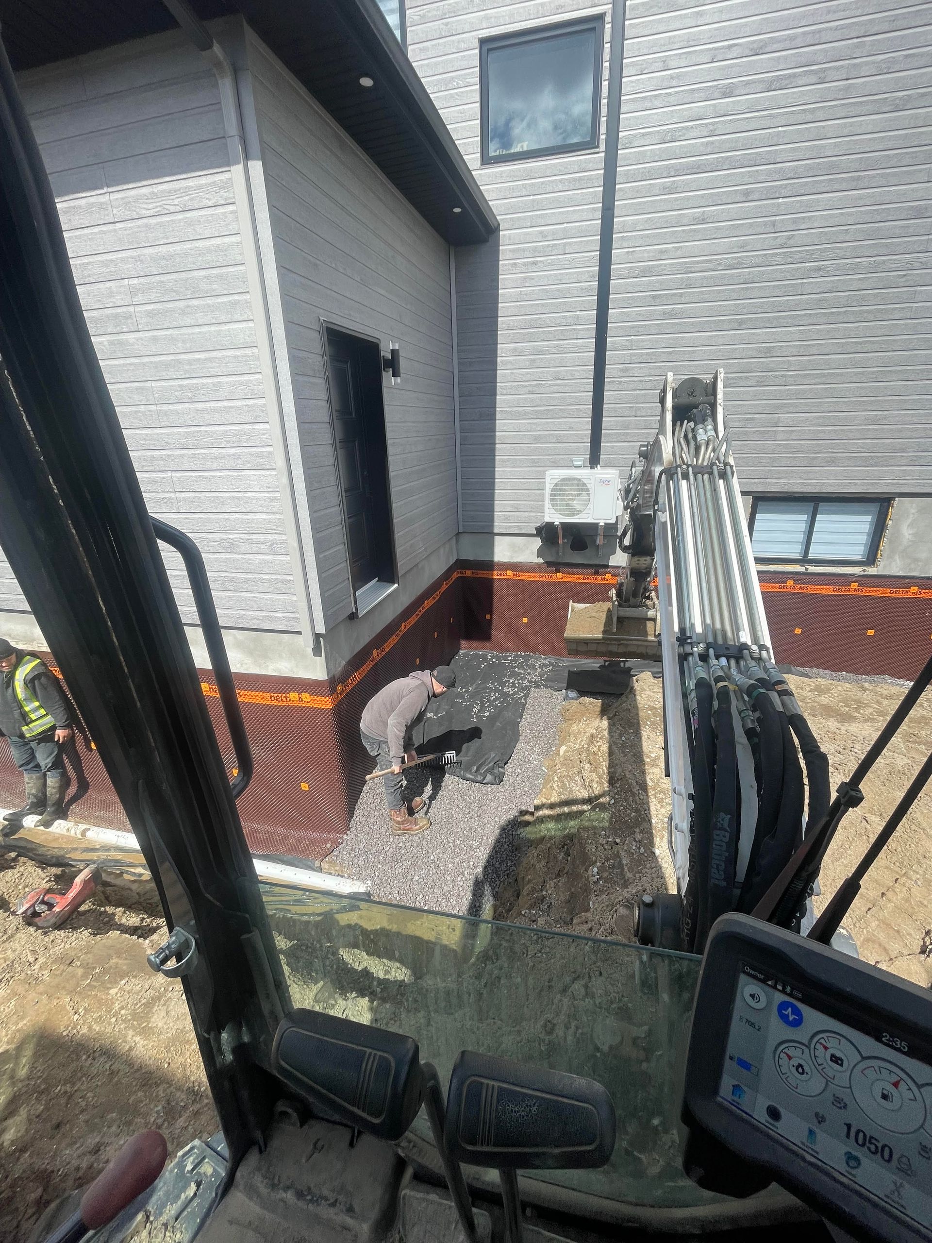 Un véhicule de chantier est garé devant une maison.