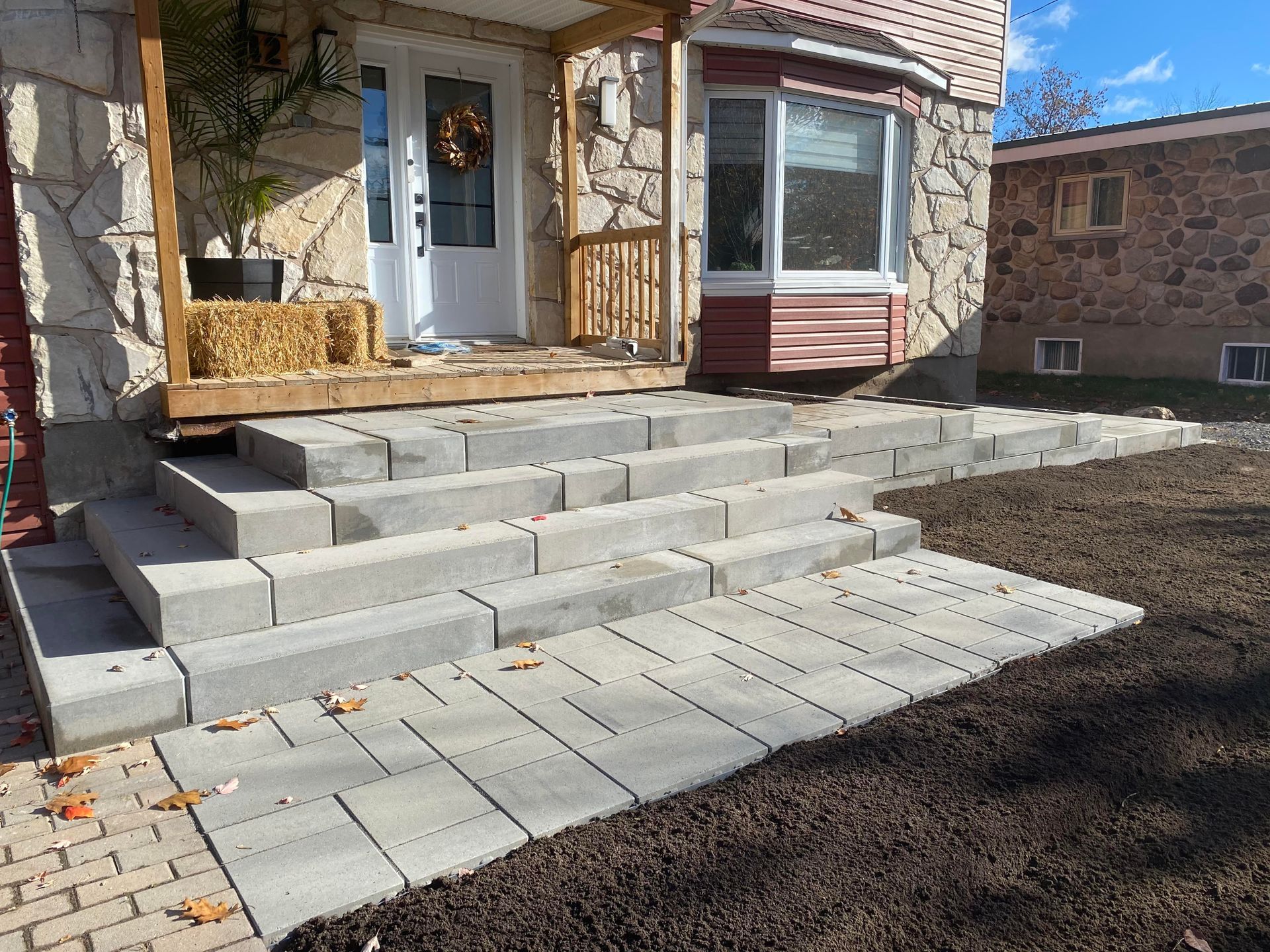 Une maison avec un porche et des escaliers qui y mènent