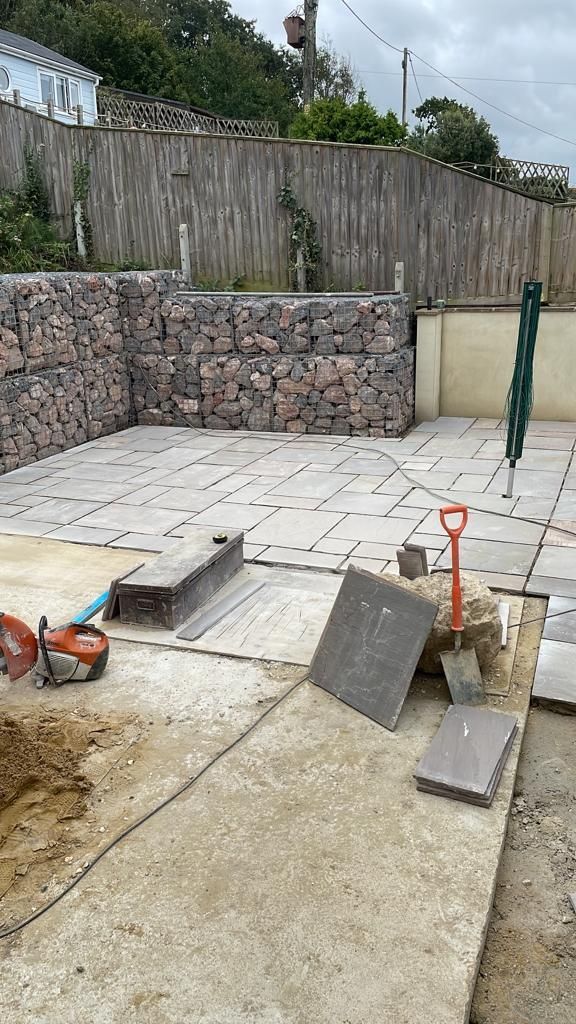A patio is being built in a backyard. Gabion baskets Isle of Wight