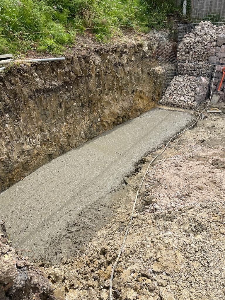 A concrete slab is being poured into a hole in the ground. Isle of Wight
