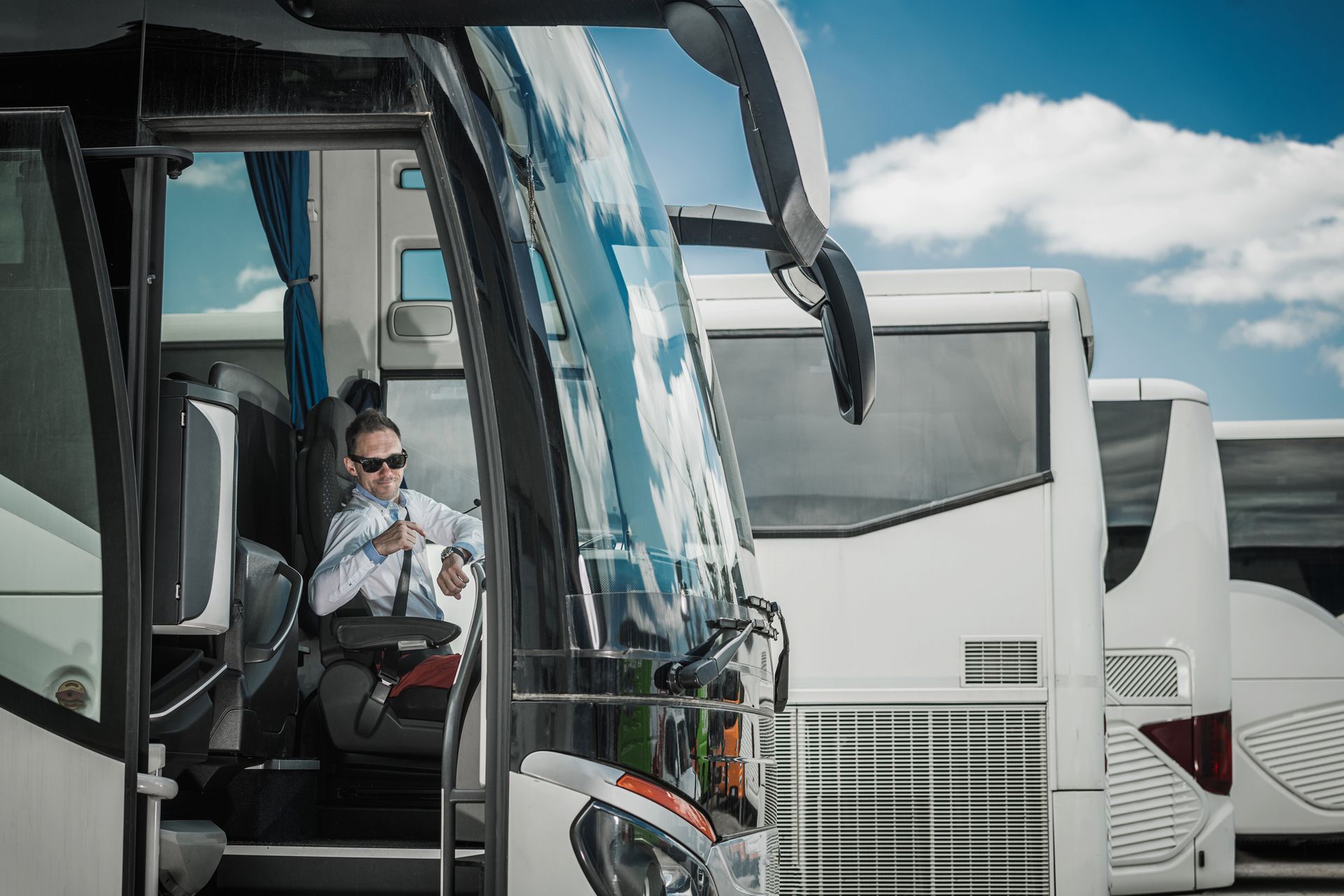 Bus driver checking wristwatch, ensuring timely service for bus rental and group transportation.