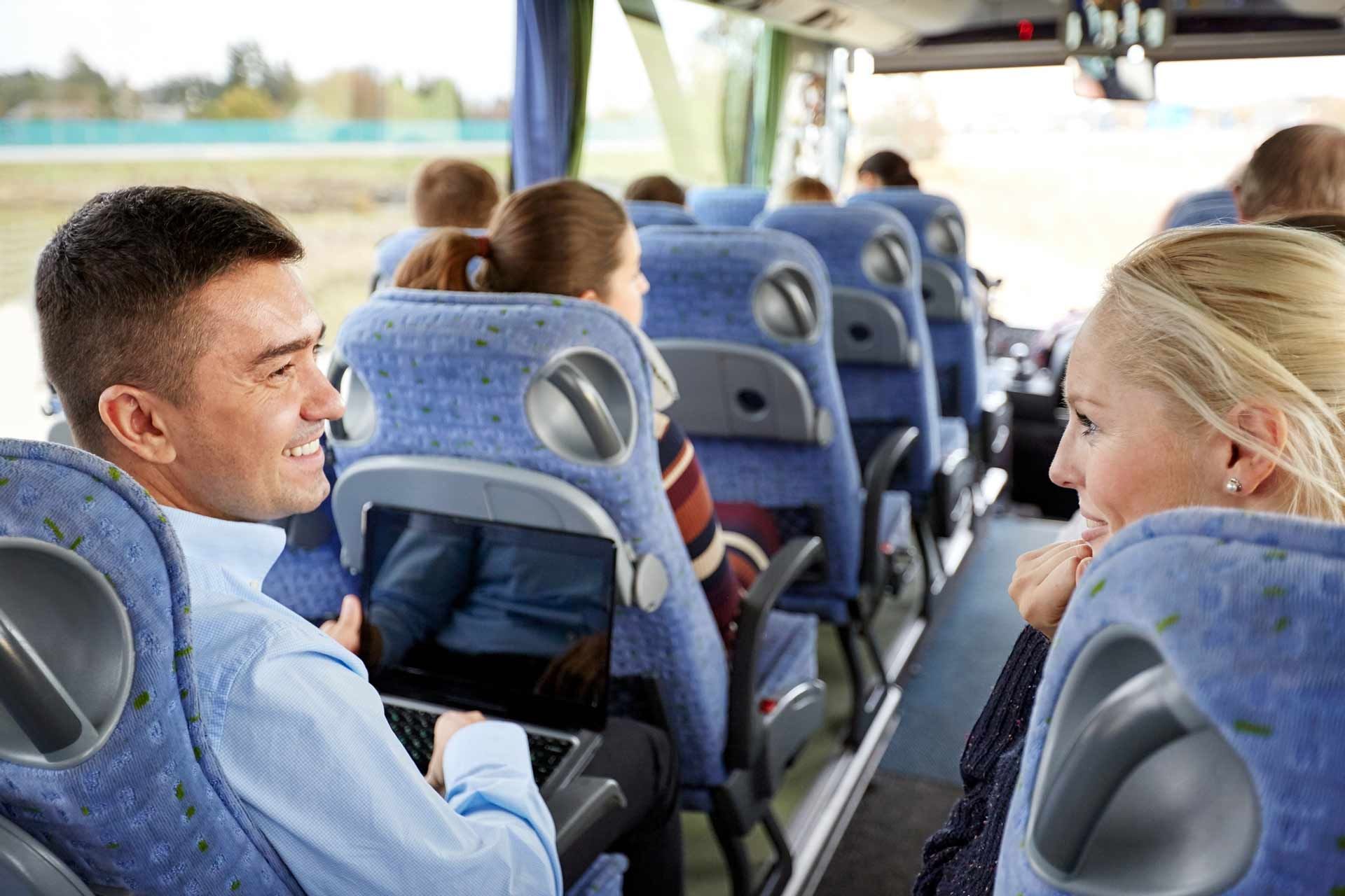 Group of happy passengers enjoying a bus rental from Cardinal Transportation, LTD, in Delaware, OH