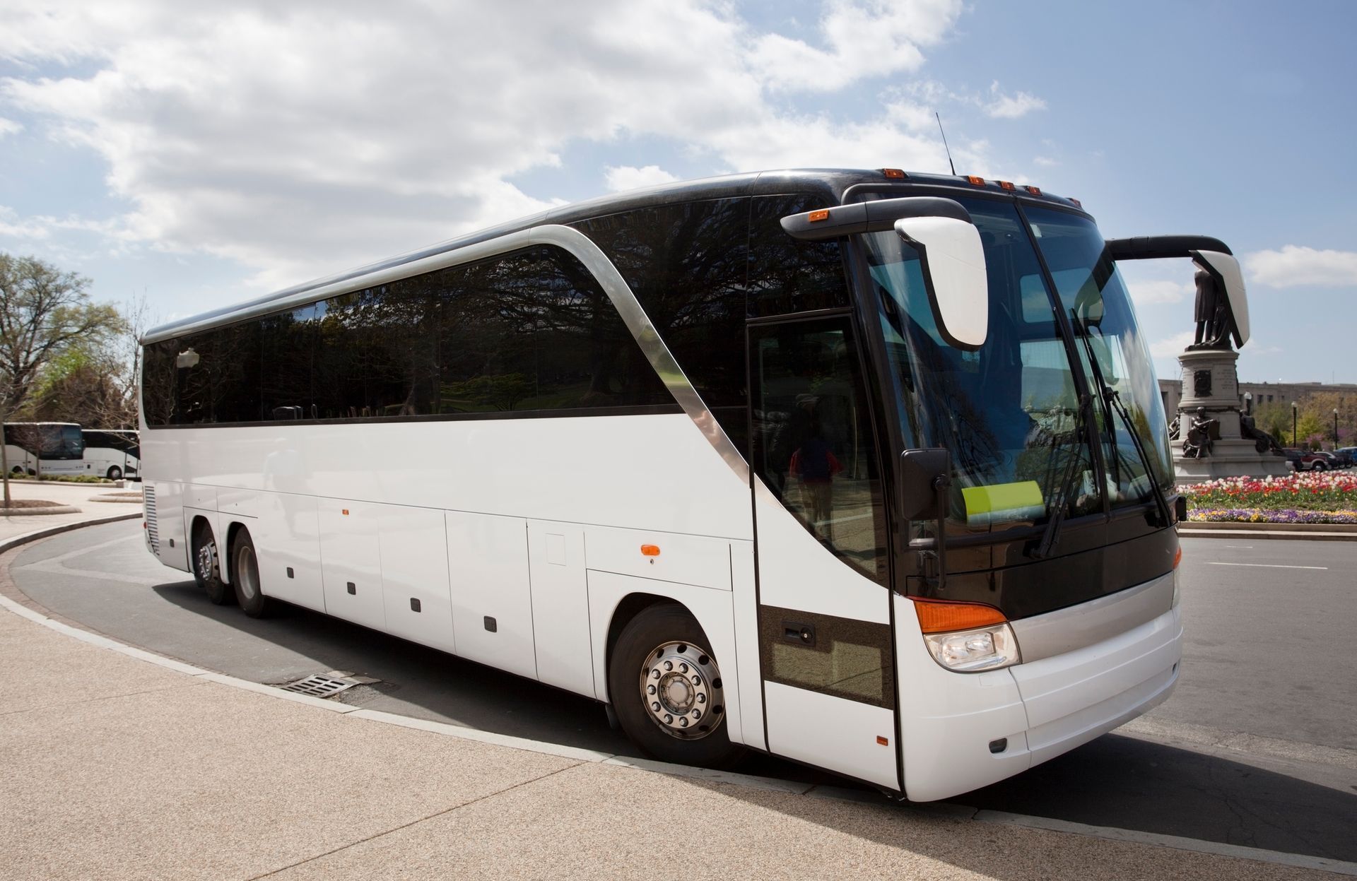 Modern charter tour bus parked in a scenic area, ideal for group travel and bus rental services.