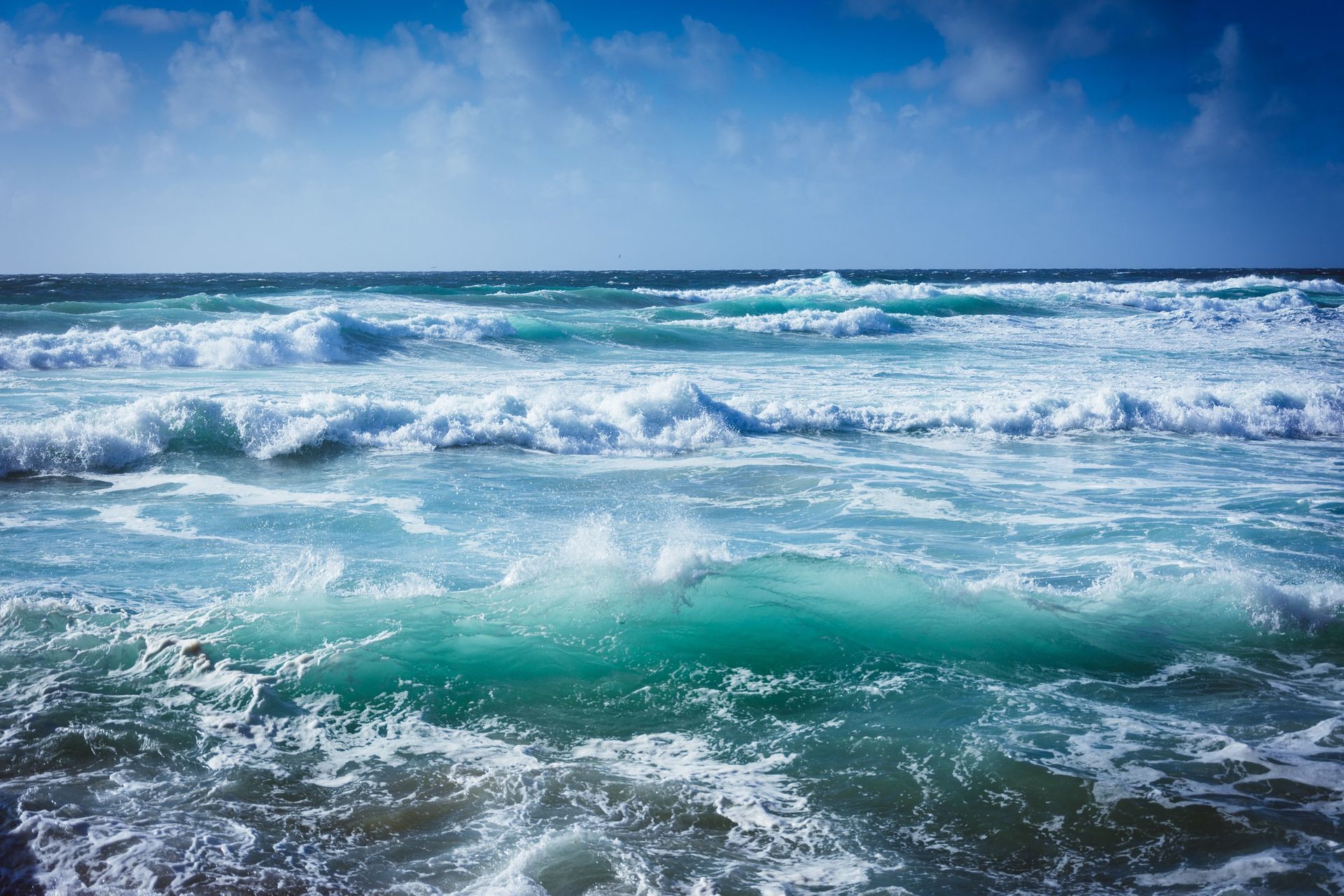 A large body of water with waves crashing on the shore.