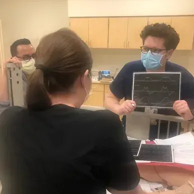 A person is holding a pineapple in a bag in a grocery store.