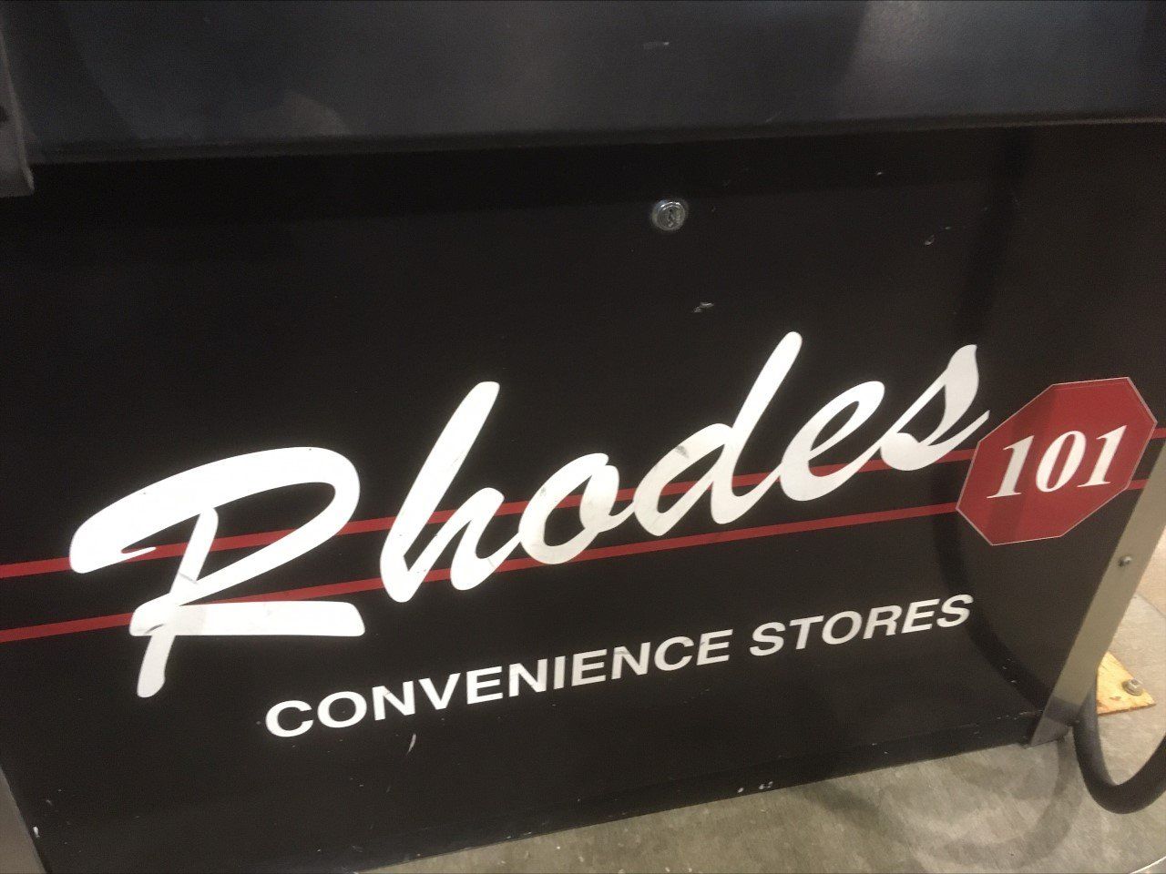Rhodes 101 convenience stores sign on a black background