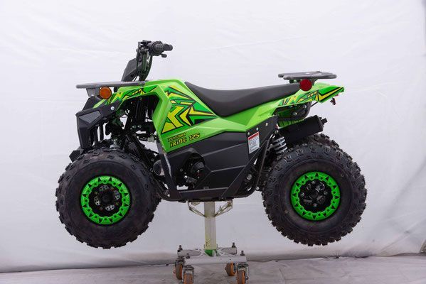 A green and black atv is sitting on a cart.