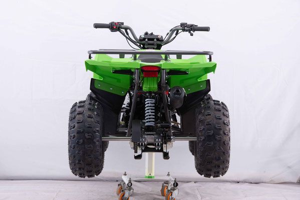 A green atv is sitting on top of a white table.