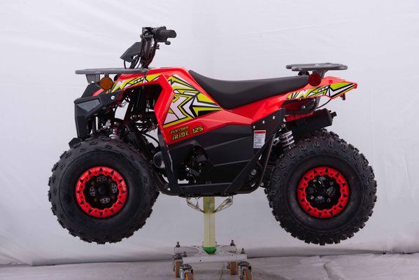 A red and black atv is sitting on a stand.