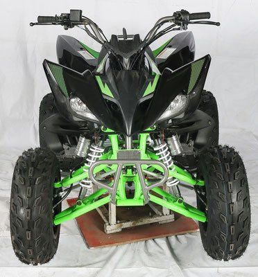 A black and green atv is sitting on a wooden platform.
