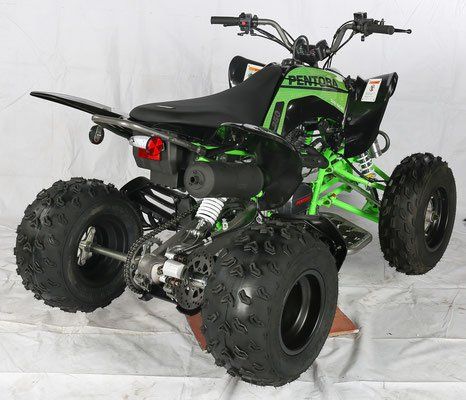 A green and black atv is sitting on a white surface.