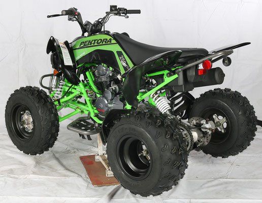 A green and black atv is sitting on a white surface.