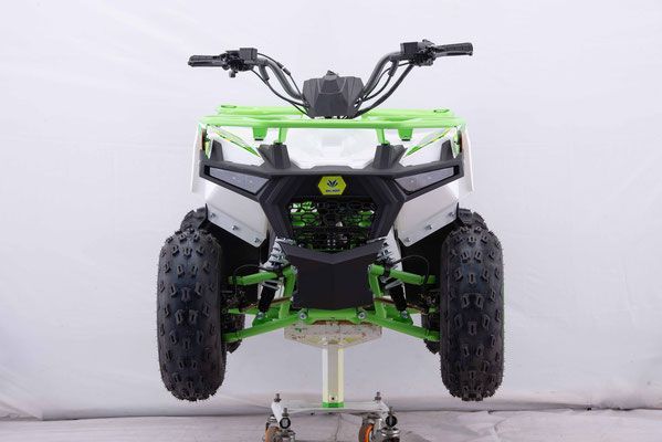 A green and white atv is sitting on top of a white table.