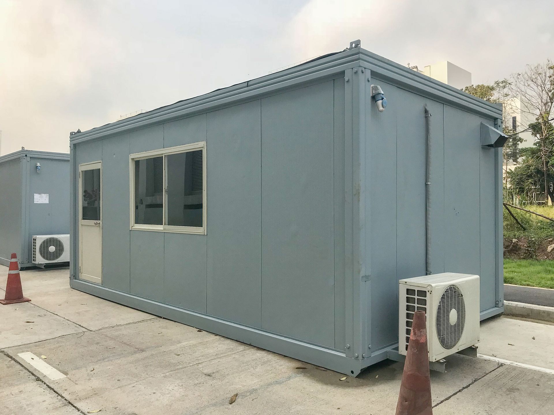 A functional container house with an air conditioner and window, available for mobile storage rental