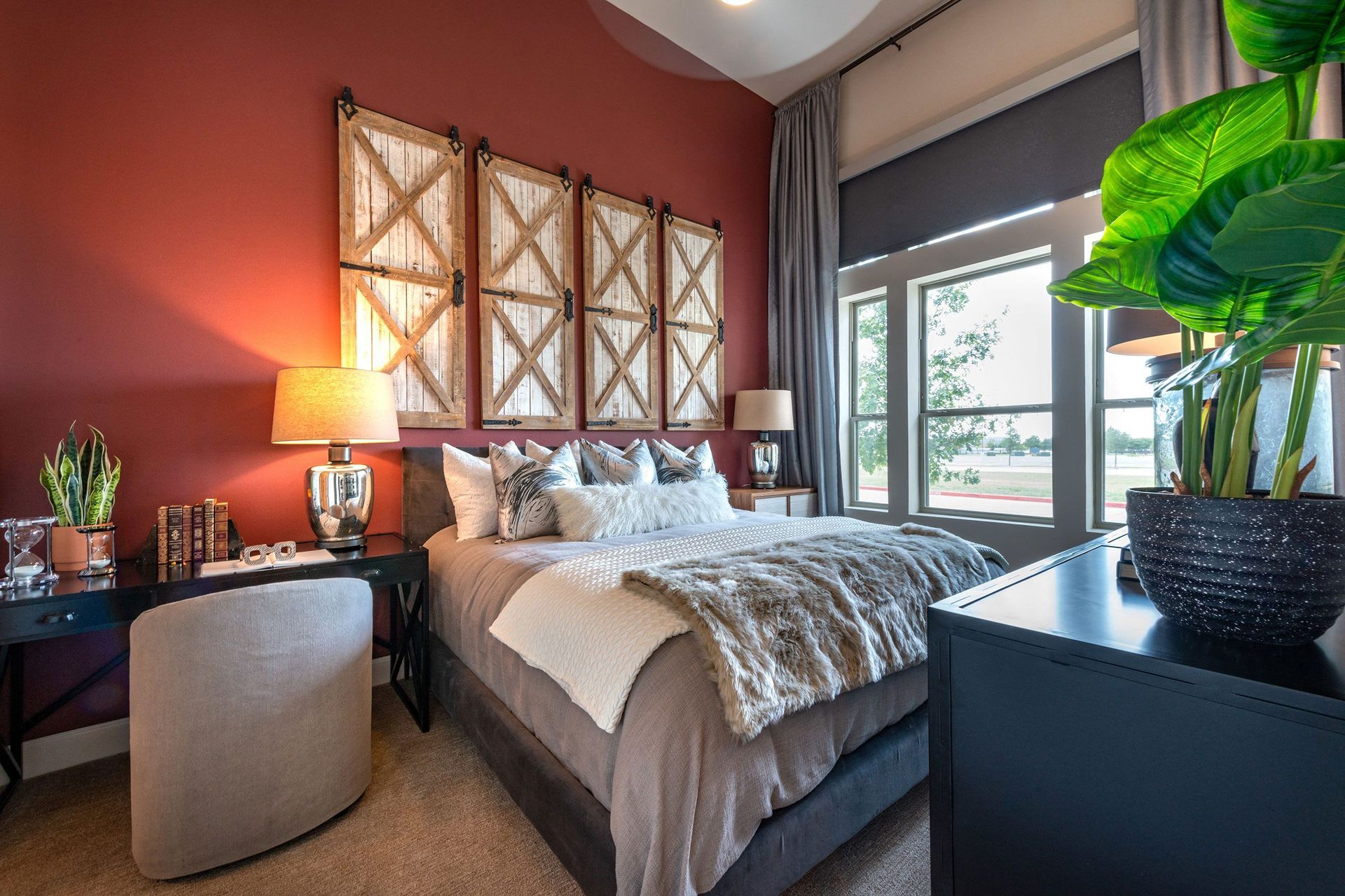 A bedroom with a bed, dresser, chair, and lamps.