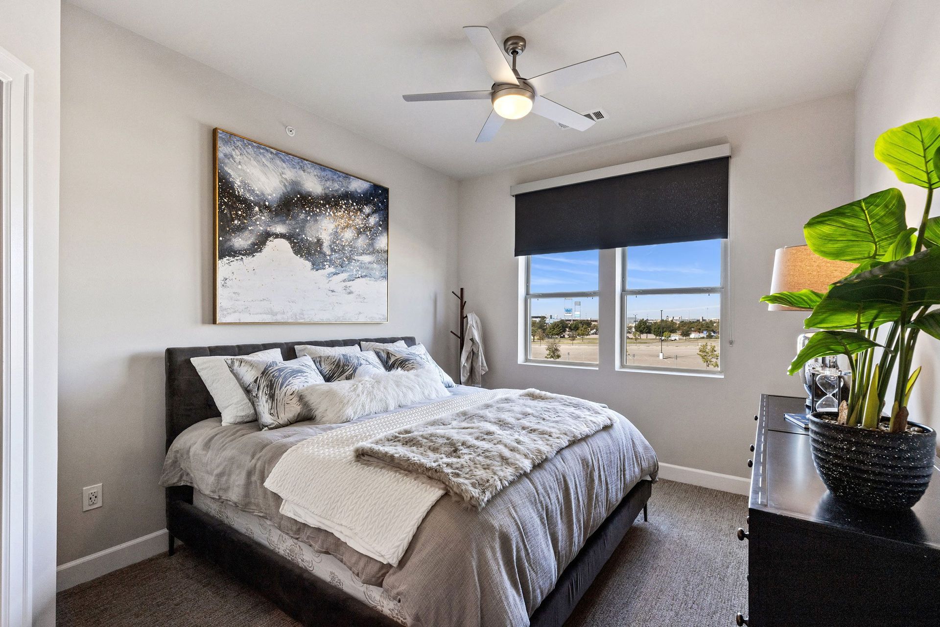 A bedroom with a large bed and a ceiling fan.