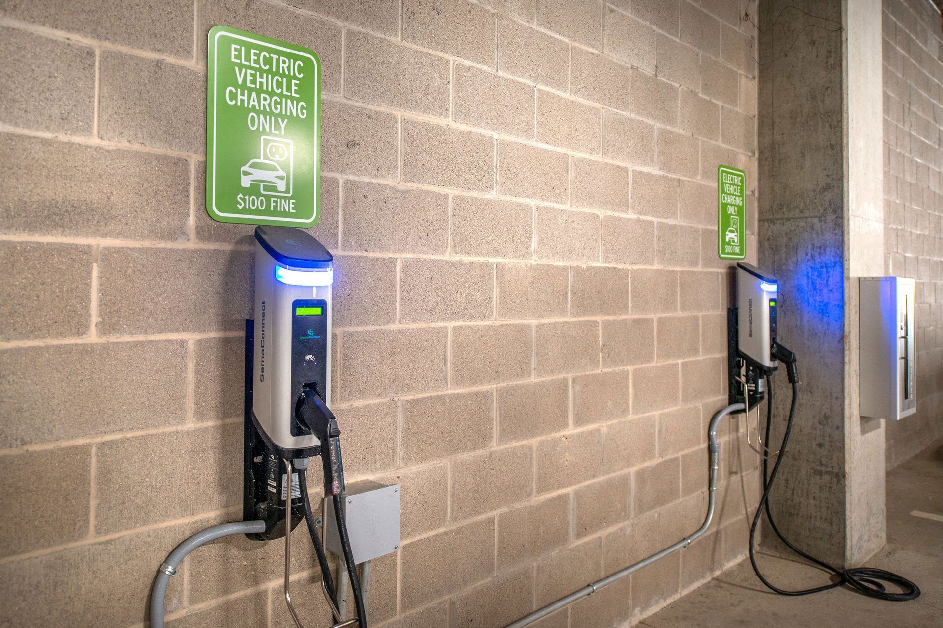 There are two electric vehicle charging stations on the wall.