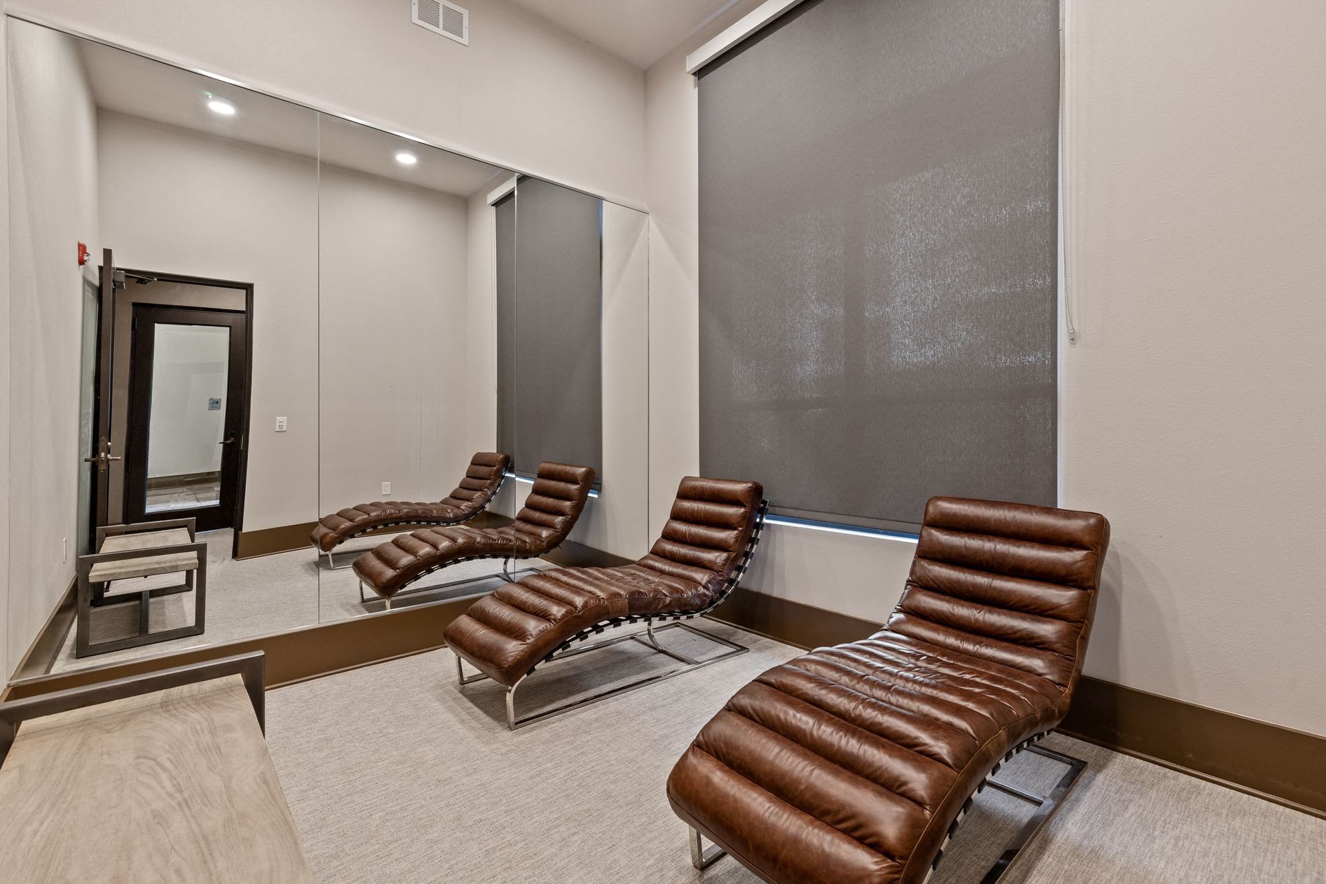 A room with a lot of chairs and a mirror.