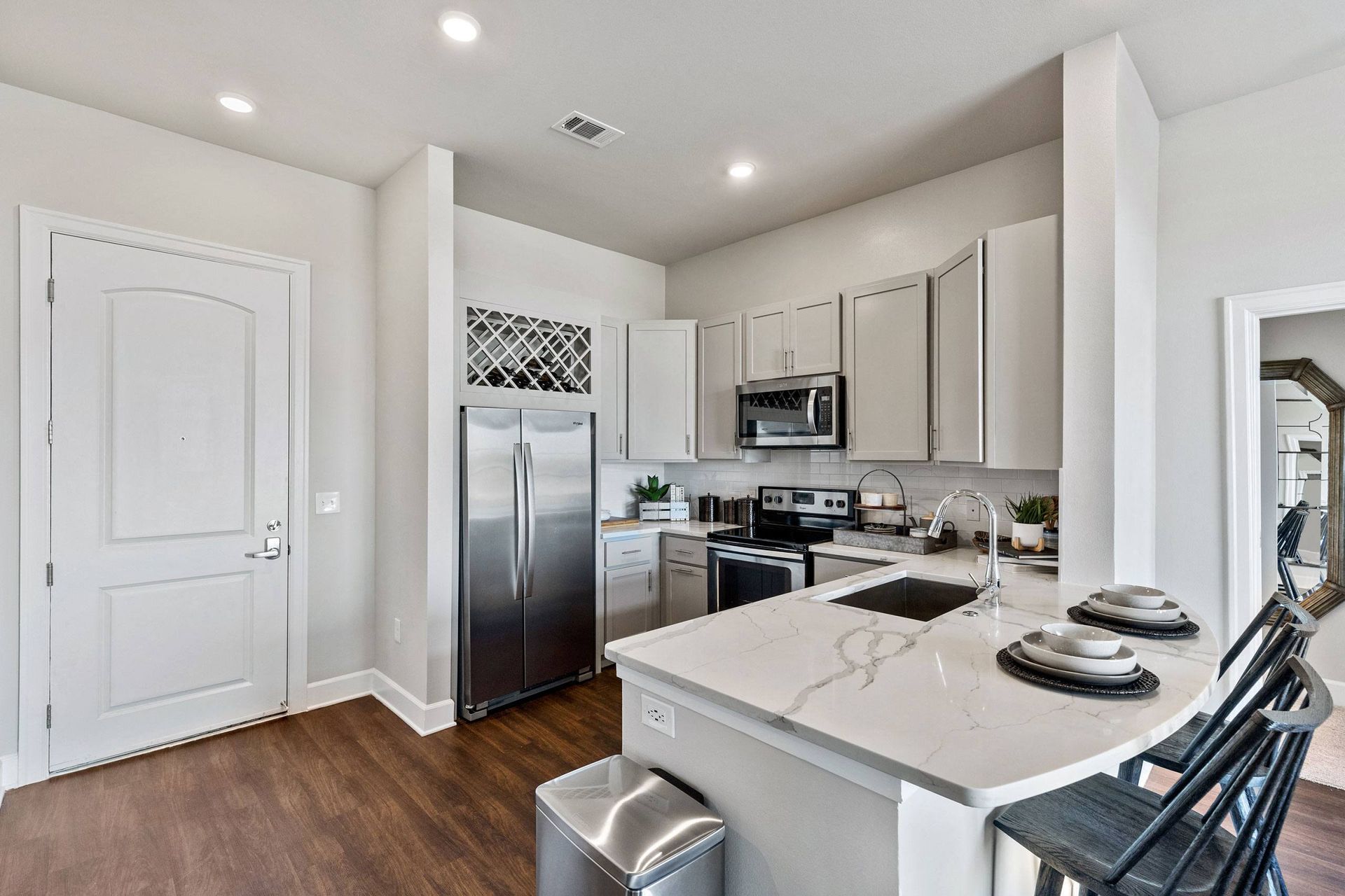 A kitchen with stainless steel appliances and white cabinets.