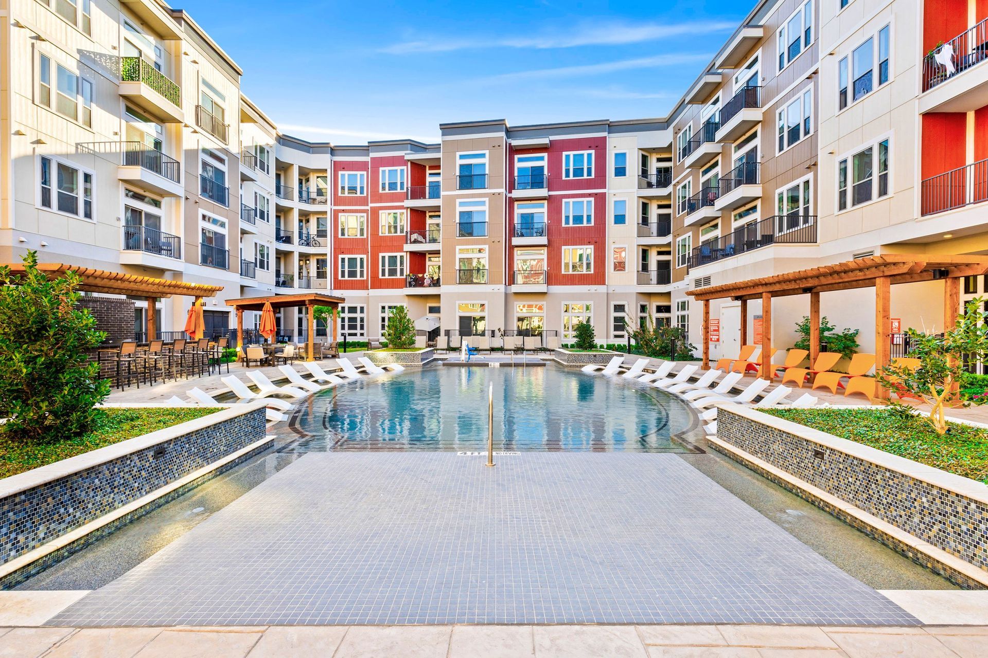 A large apartment building with a large swimming pool in the middle.