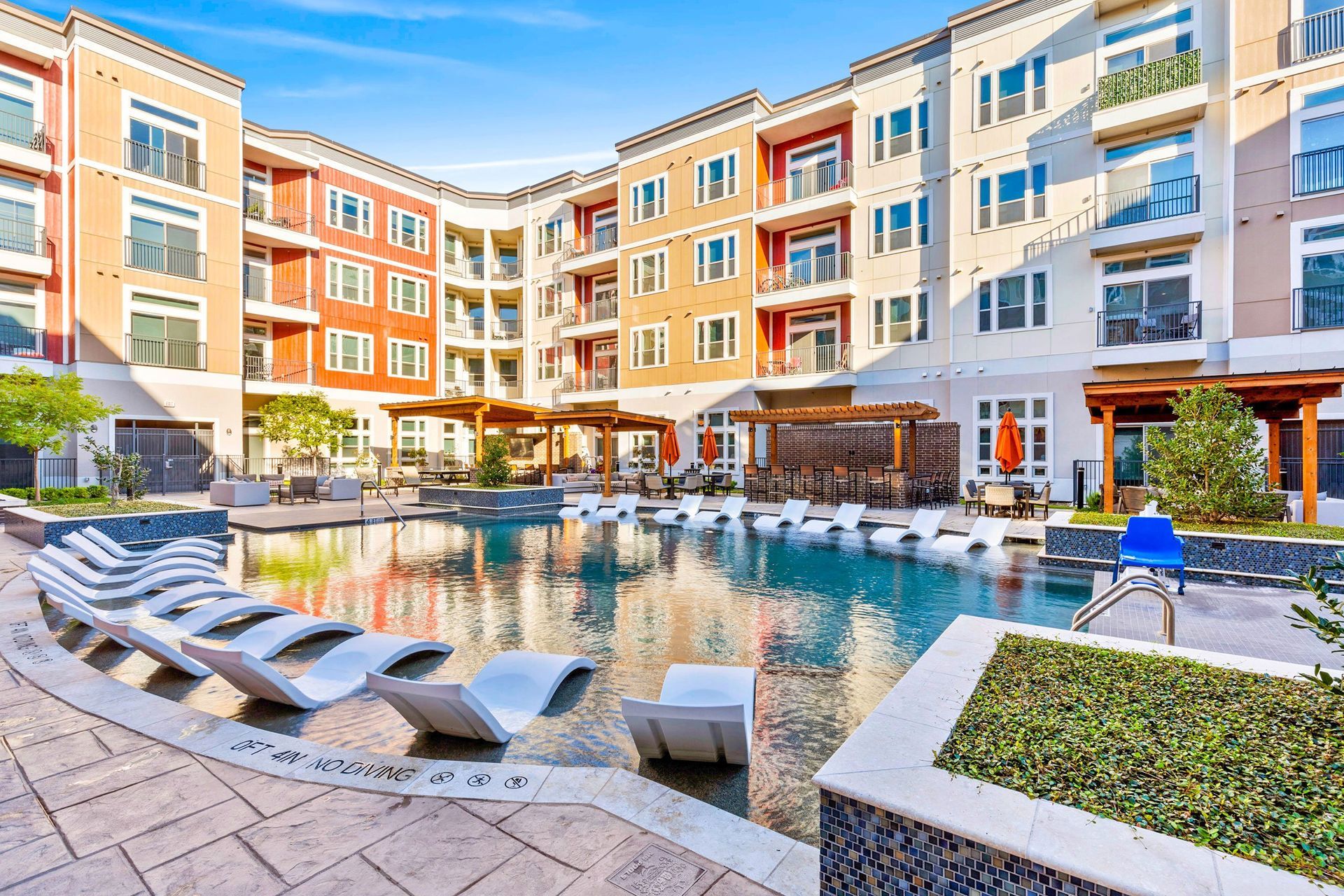 A large apartment building with a large swimming pool in front of it.