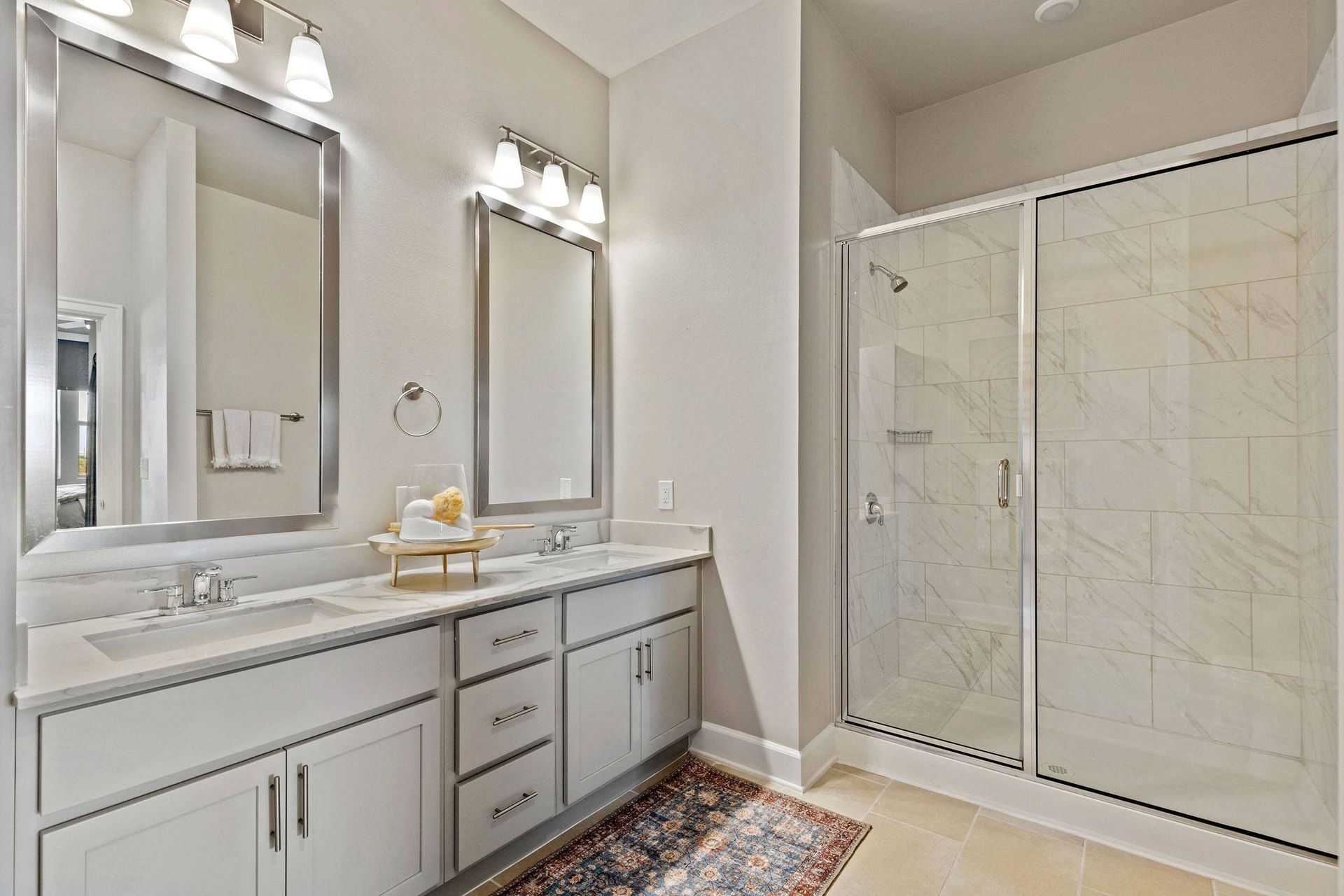 A bathroom with two sinks and a walk in shower.