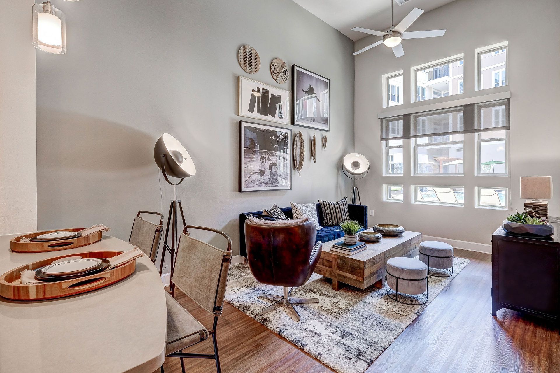 A living room with a ceiling fan and a dining table.