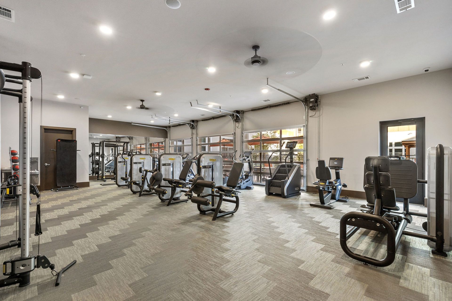 A large gym filled with lots of exercise equipment.