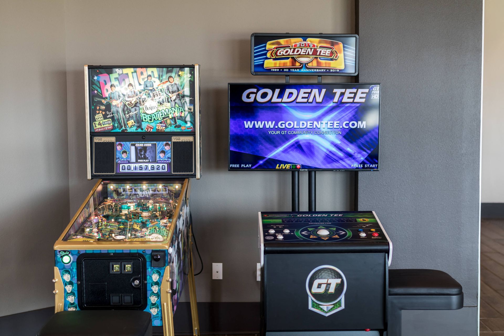 Two pinball machines are sitting next to each other in a room.