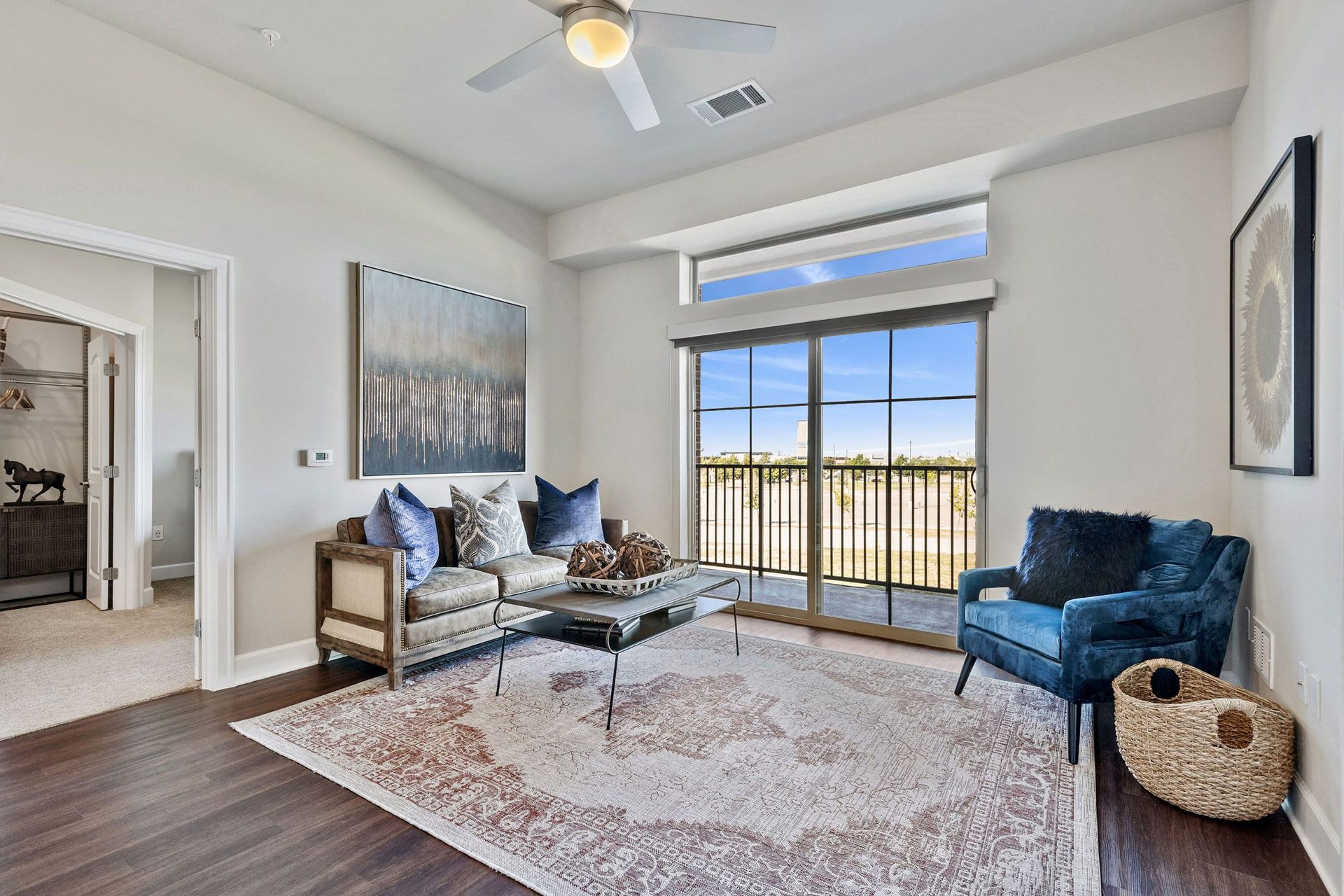 A living room with a couch, chair, coffee table, and ceiling fan.