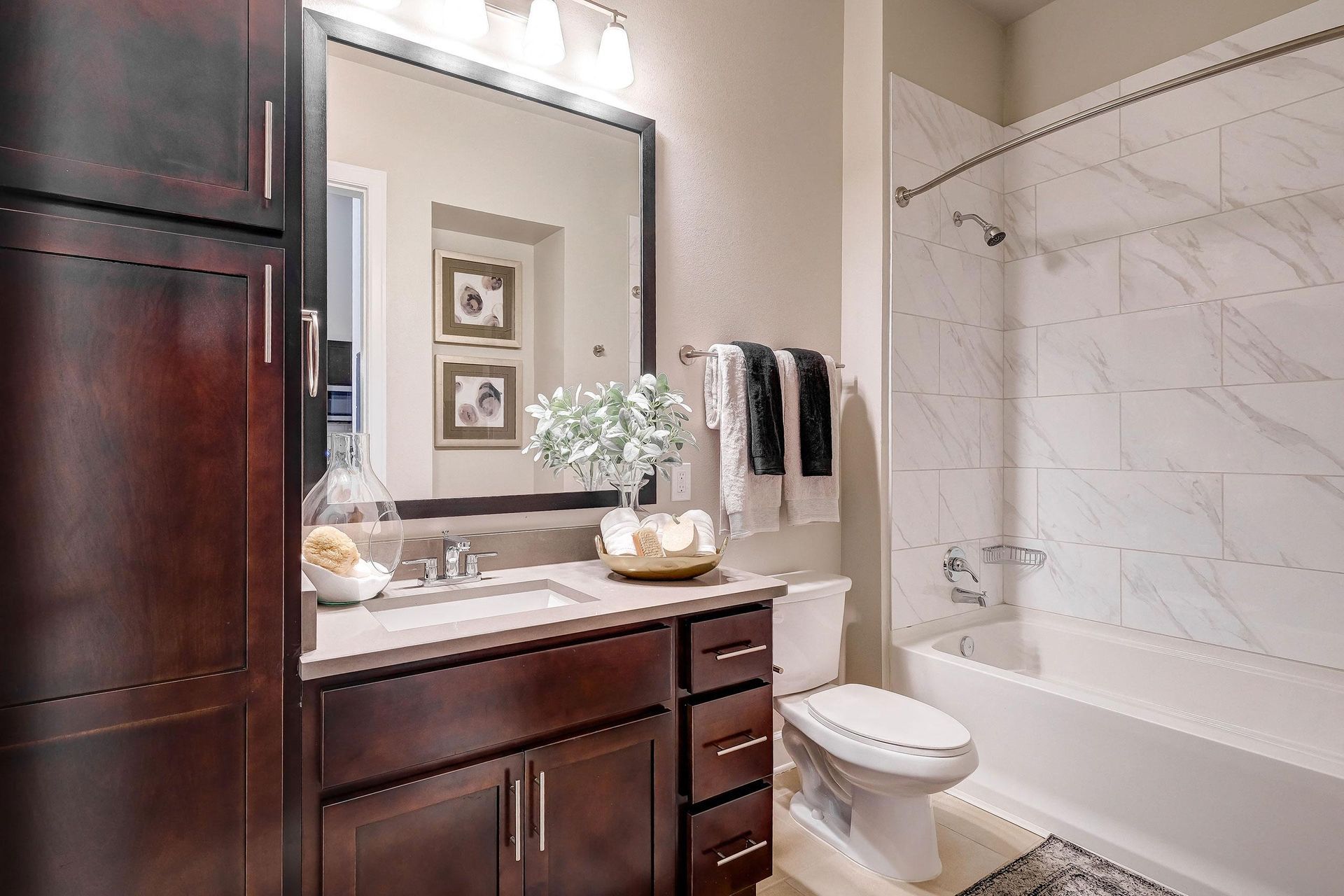 A bathroom with a sink, toilet, tub, and mirror.