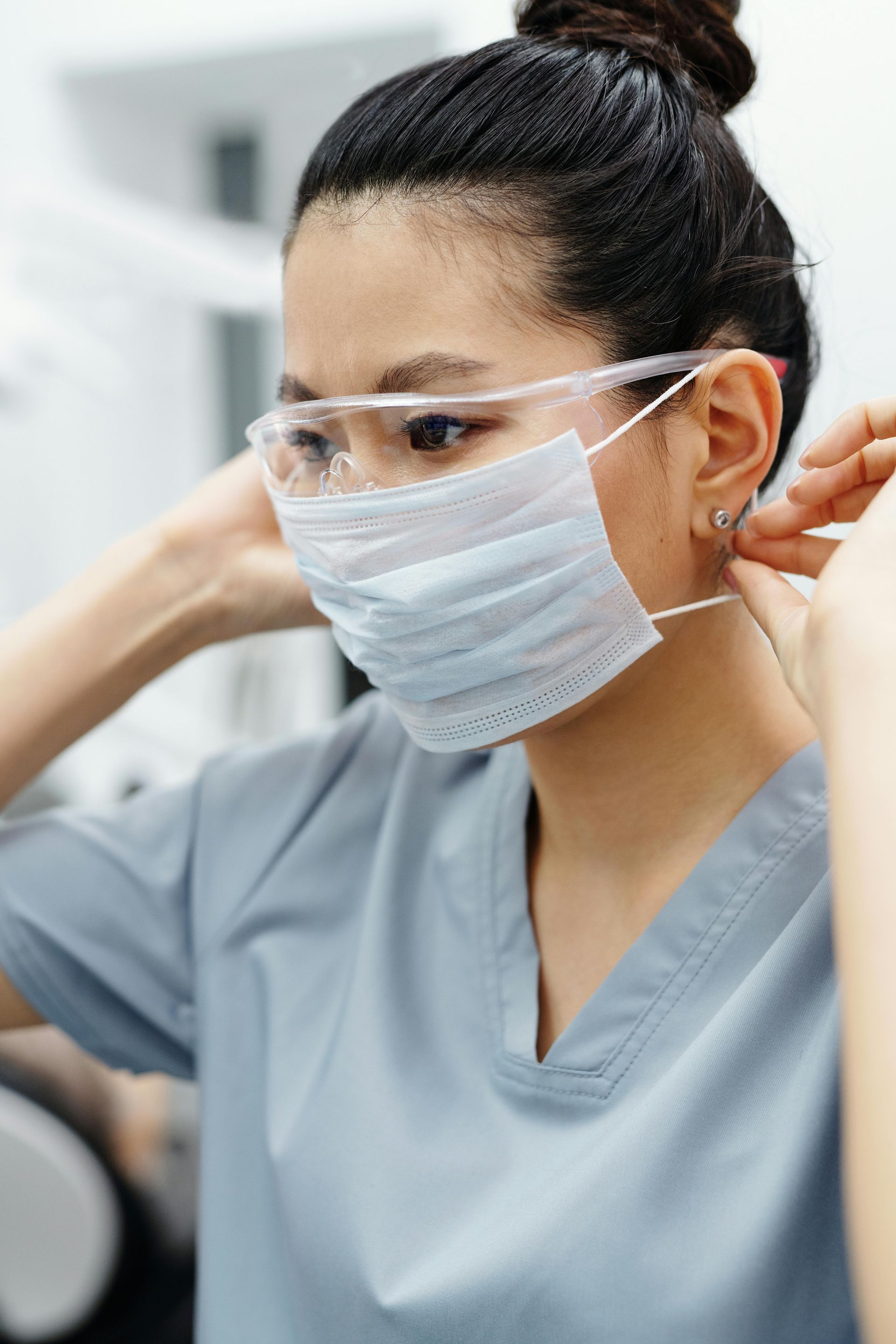 A woman wearing a surgical mask and goggles.