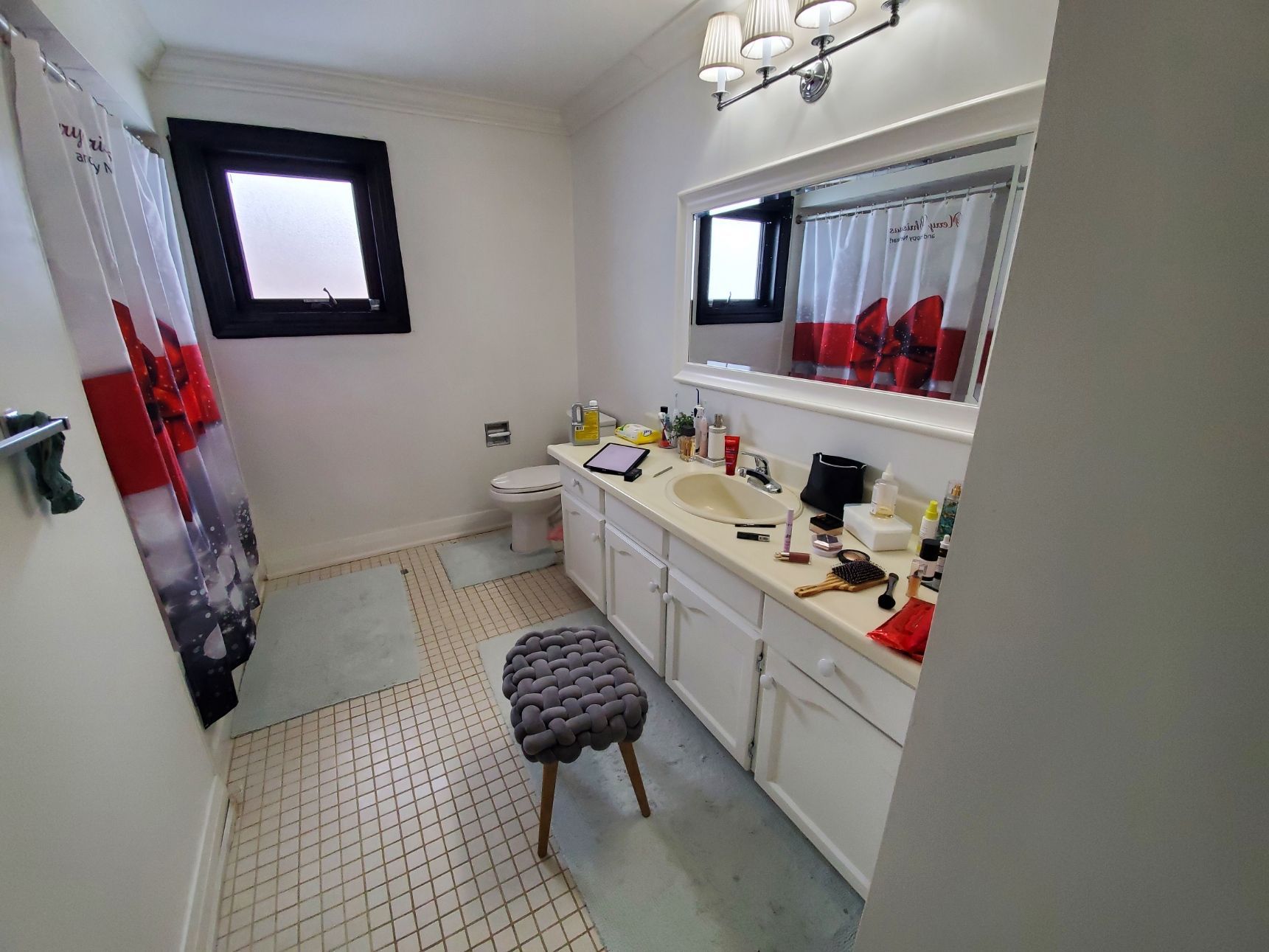 A bathroom with two sinks , a toilet , a mirror and a window.