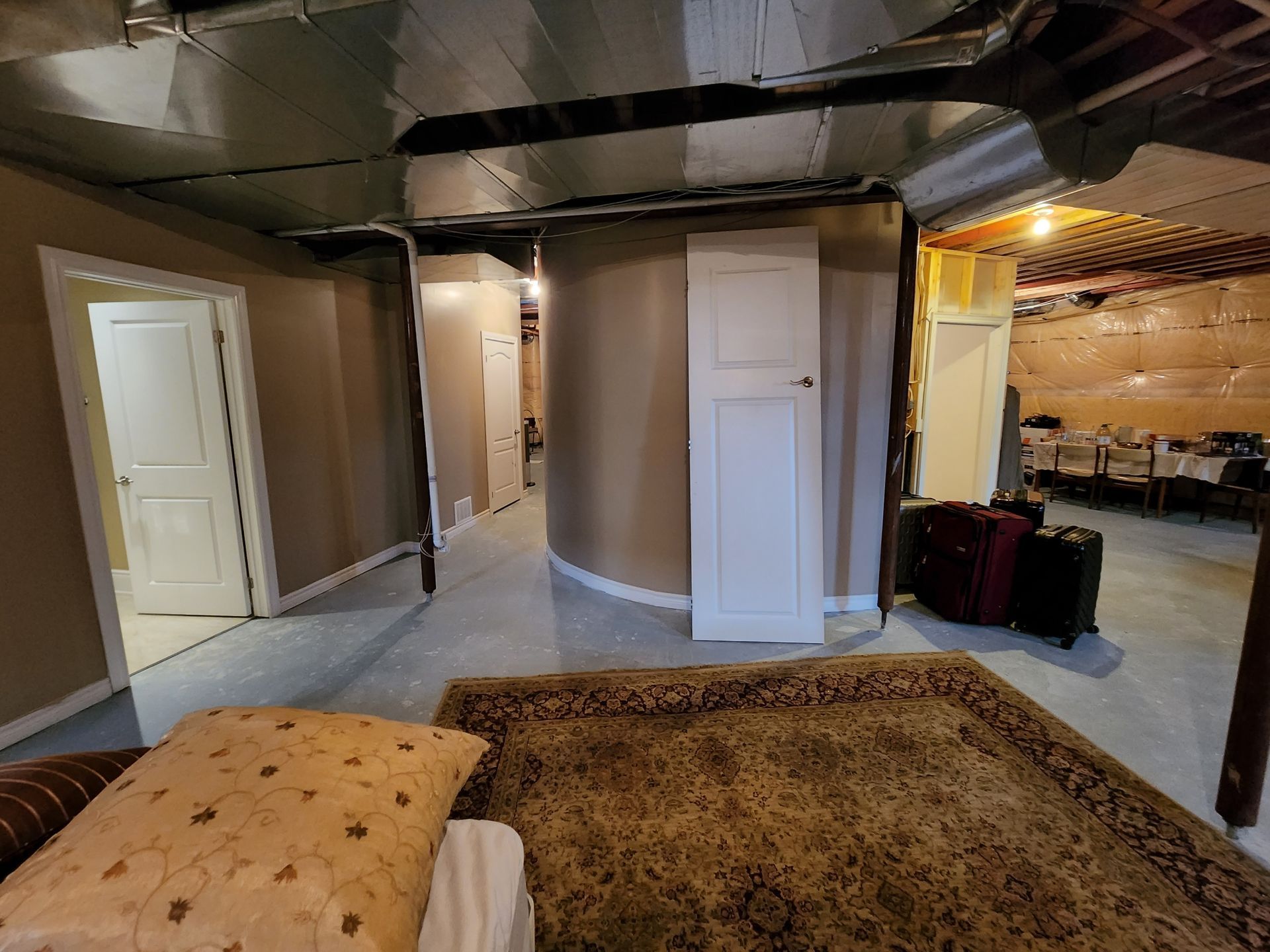 A bedroom with a bed and a rug in a basement.