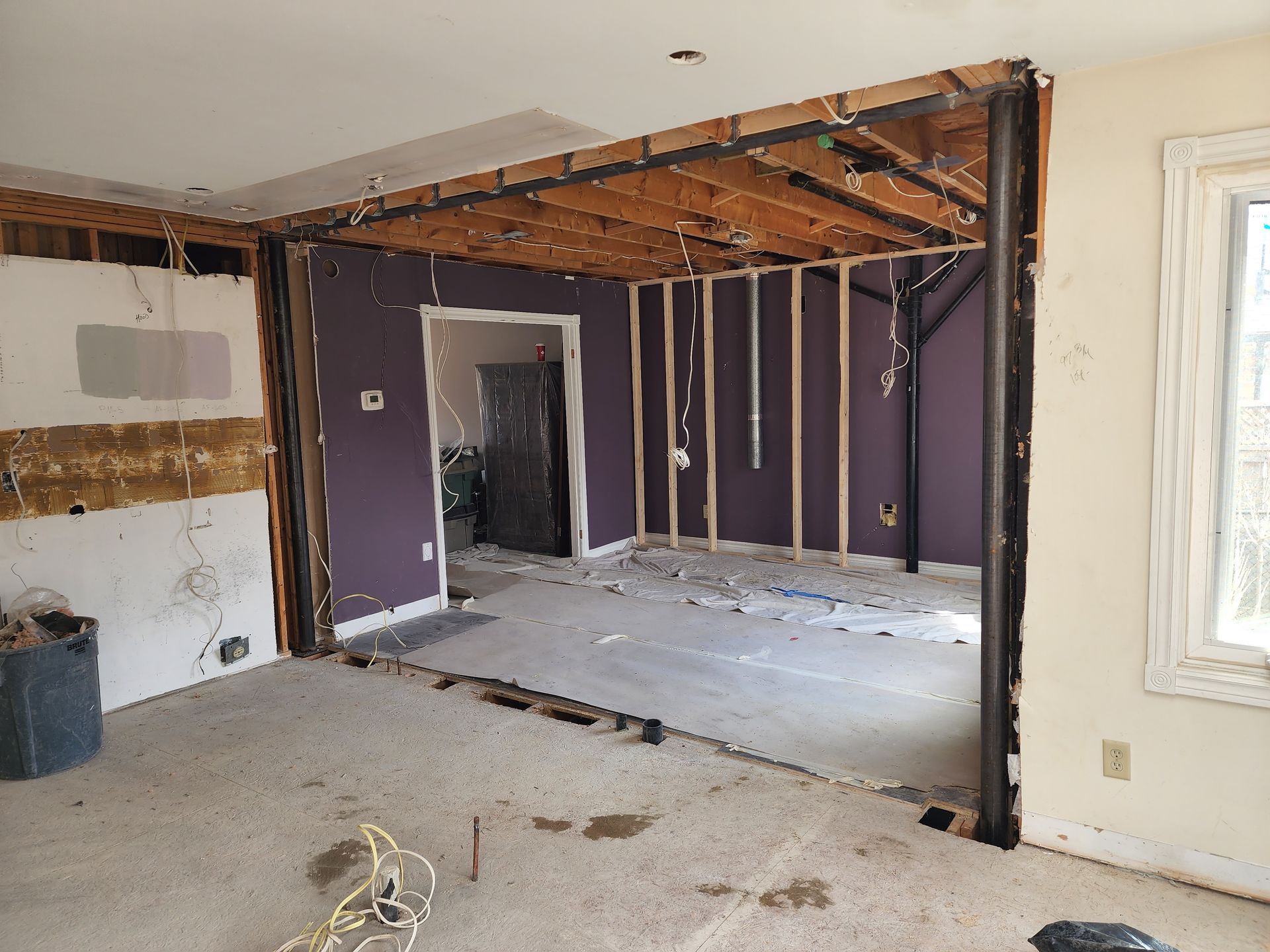 A living room with purple walls is being remodeled.