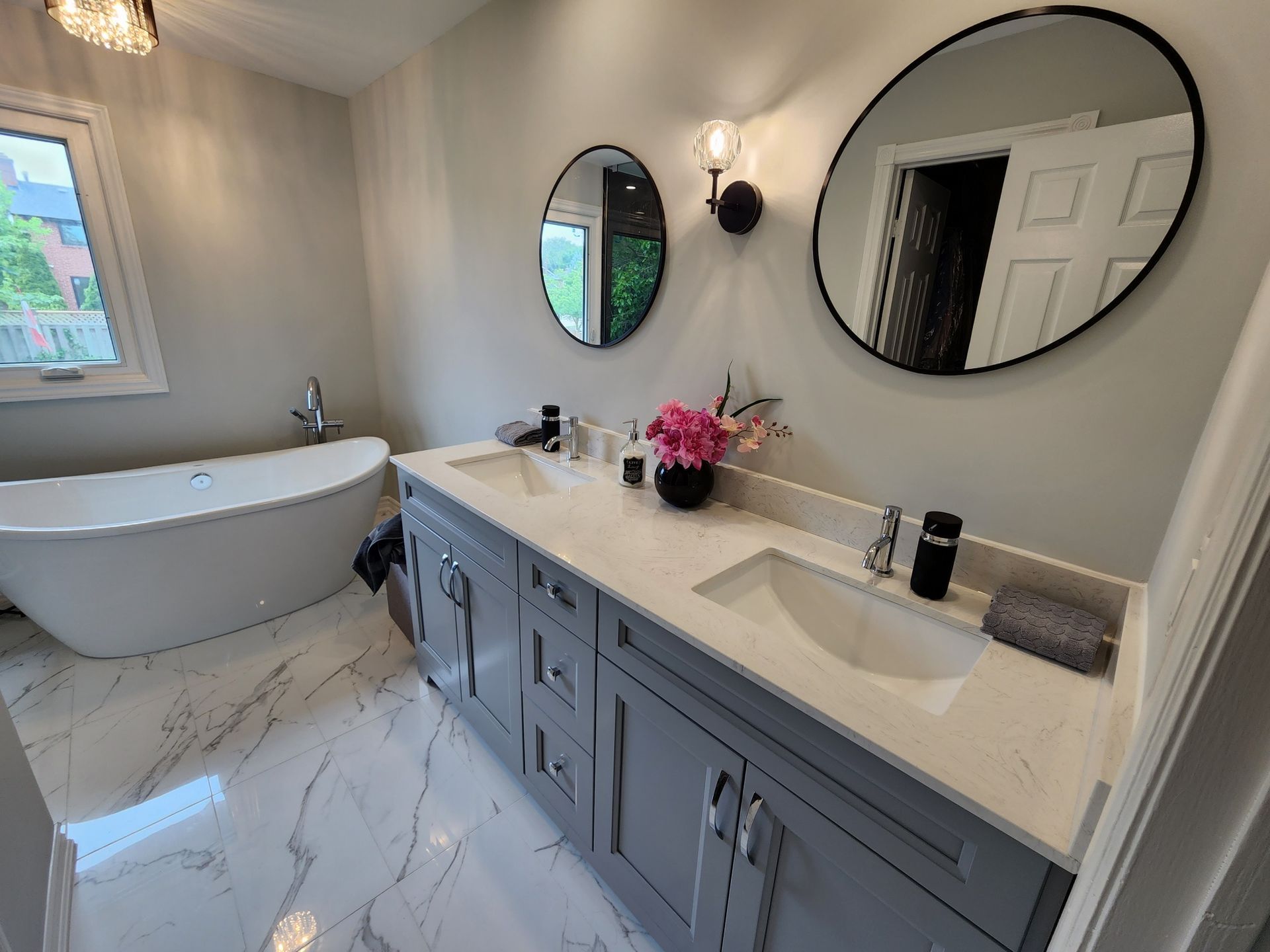 A bathroom with two sinks , two mirrors and a bathtub.