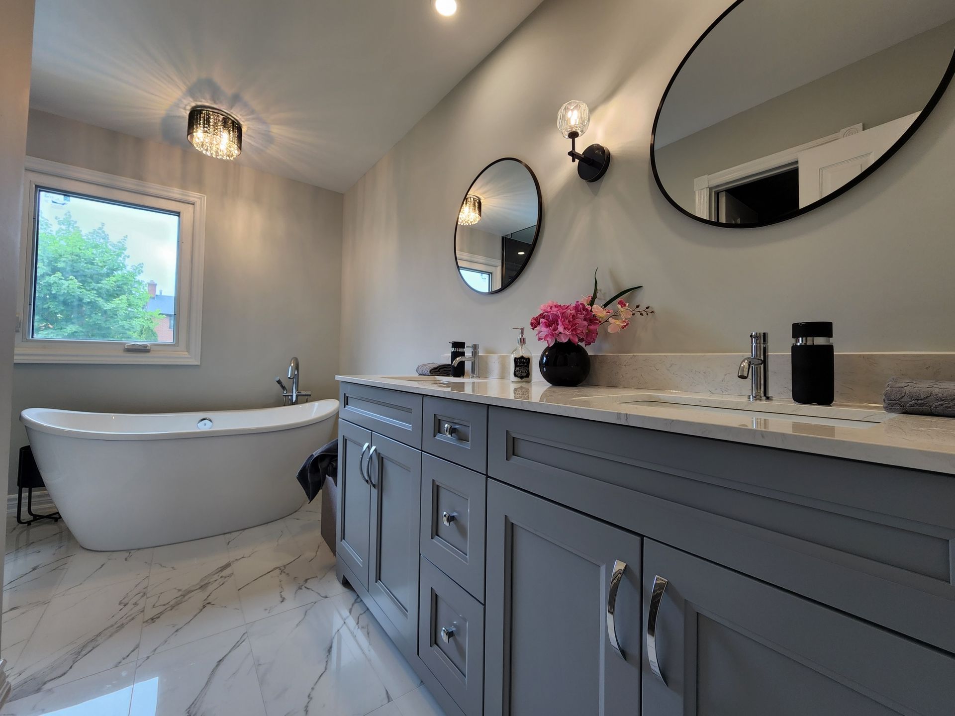 A bathroom with two sinks , two mirrors and a bathtub.