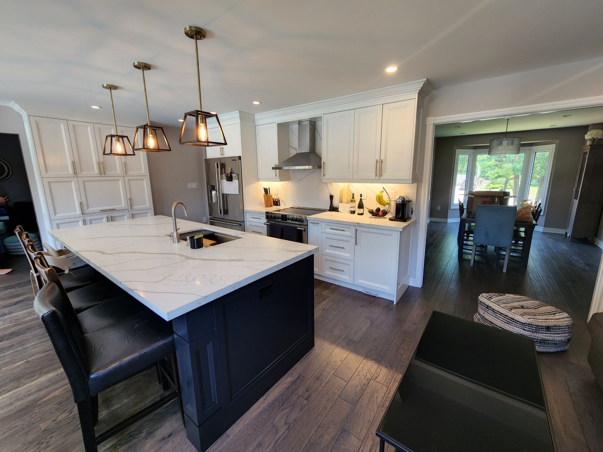 A kitchen with a large island and white cabinets