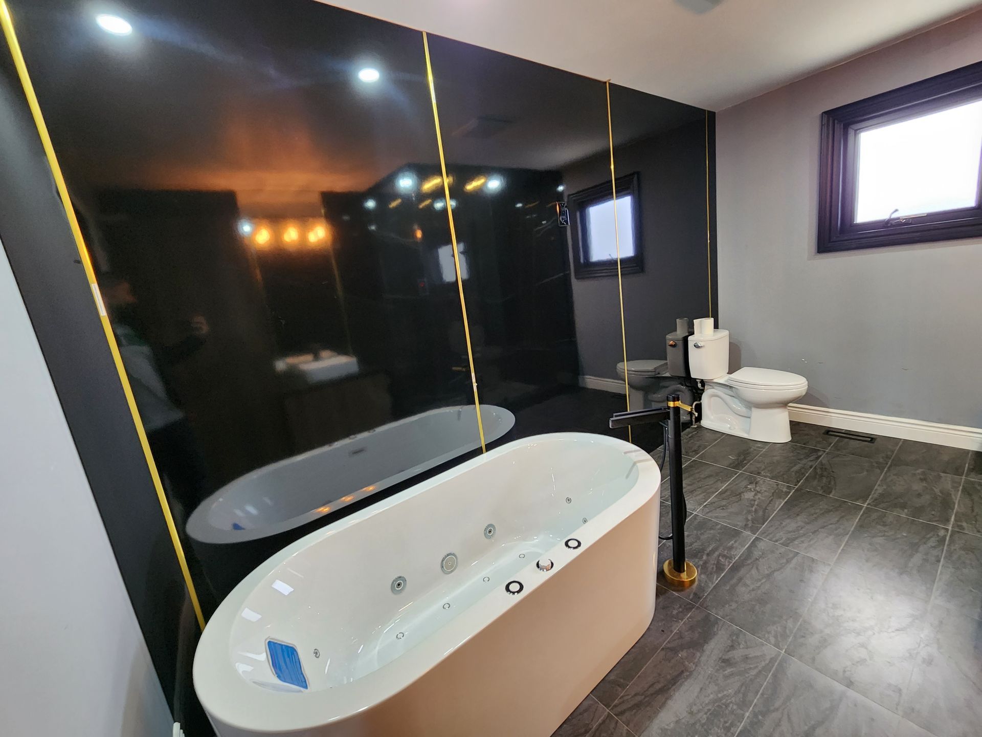 A bathroom with a bathtub , toilet and mirror.