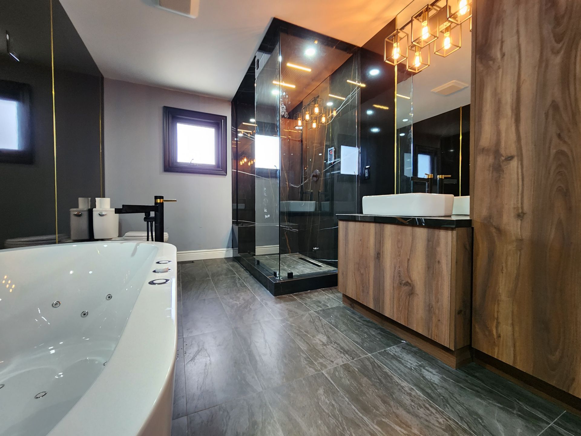 A bathroom with a jacuzzi tub , sinks , and a walk in shower.