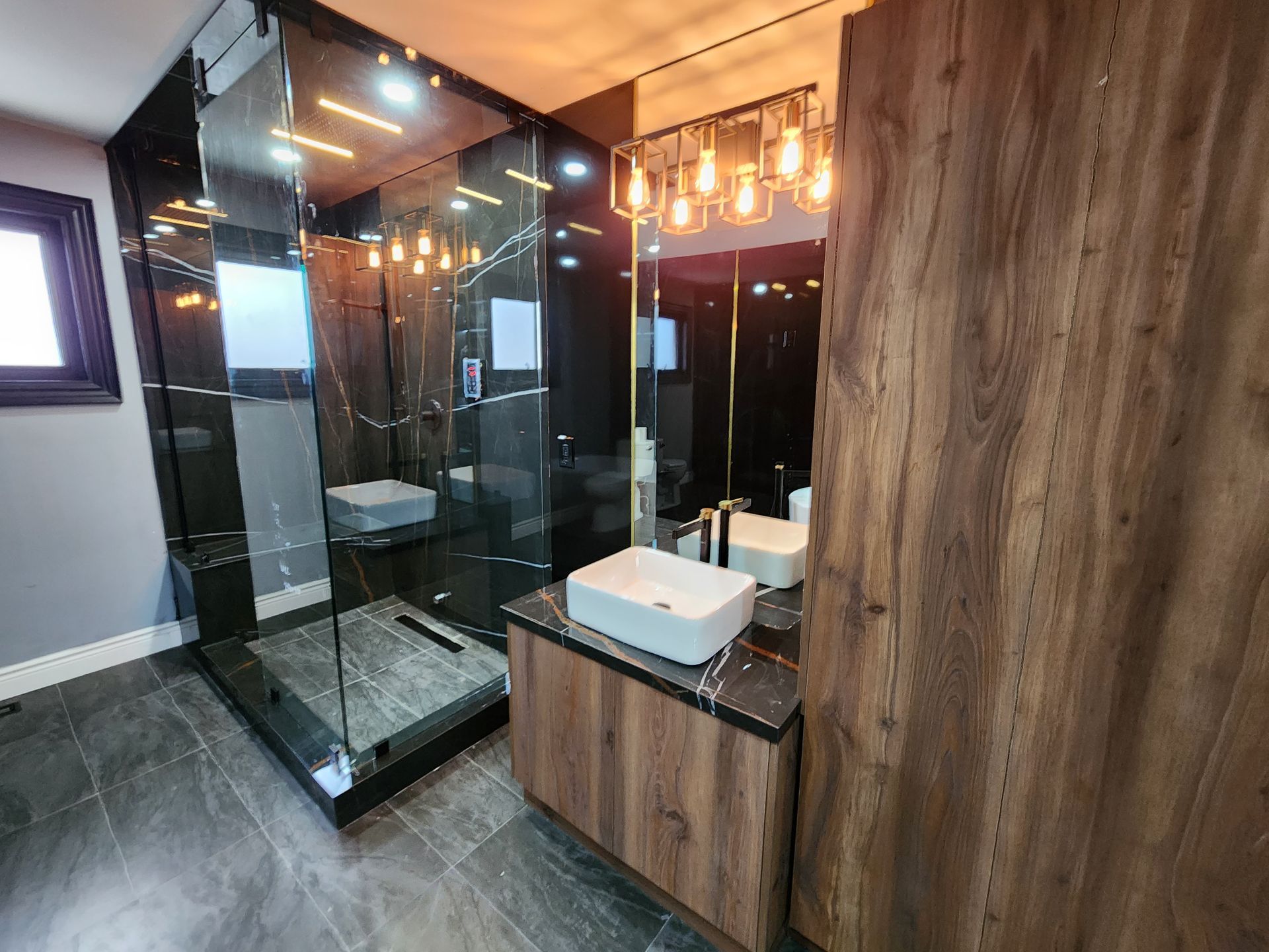 A bathroom with two sinks and a walk in shower.