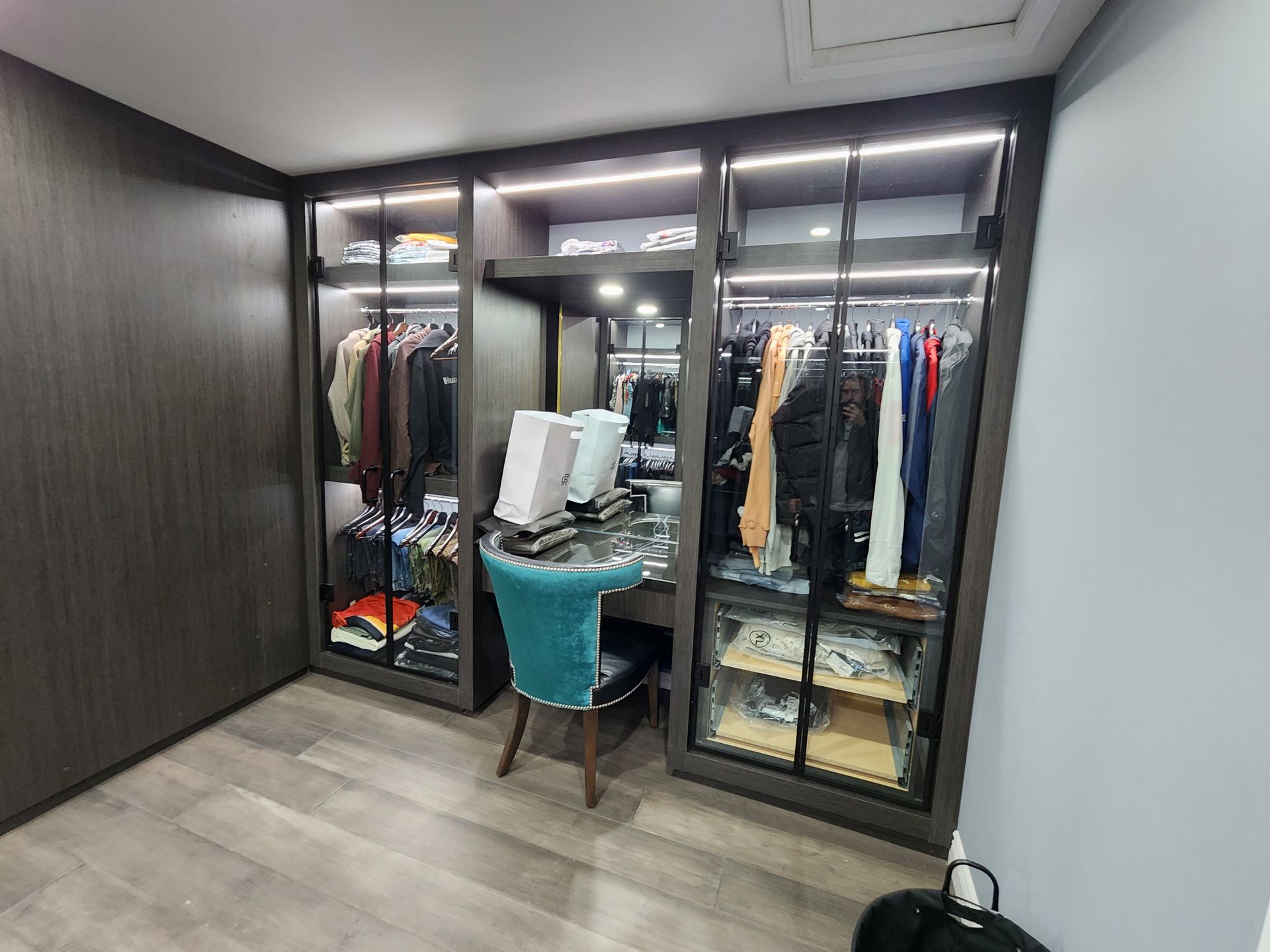 A walk in closet with a desk and chair in it.