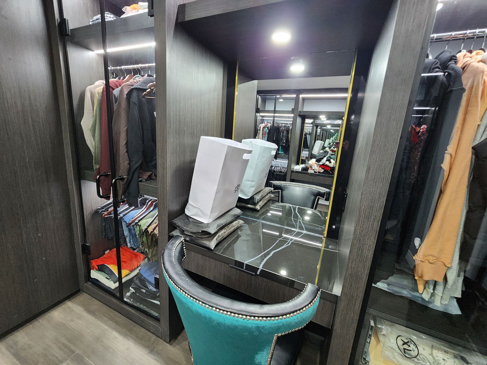A walk in closet with a vanity and a mirror.