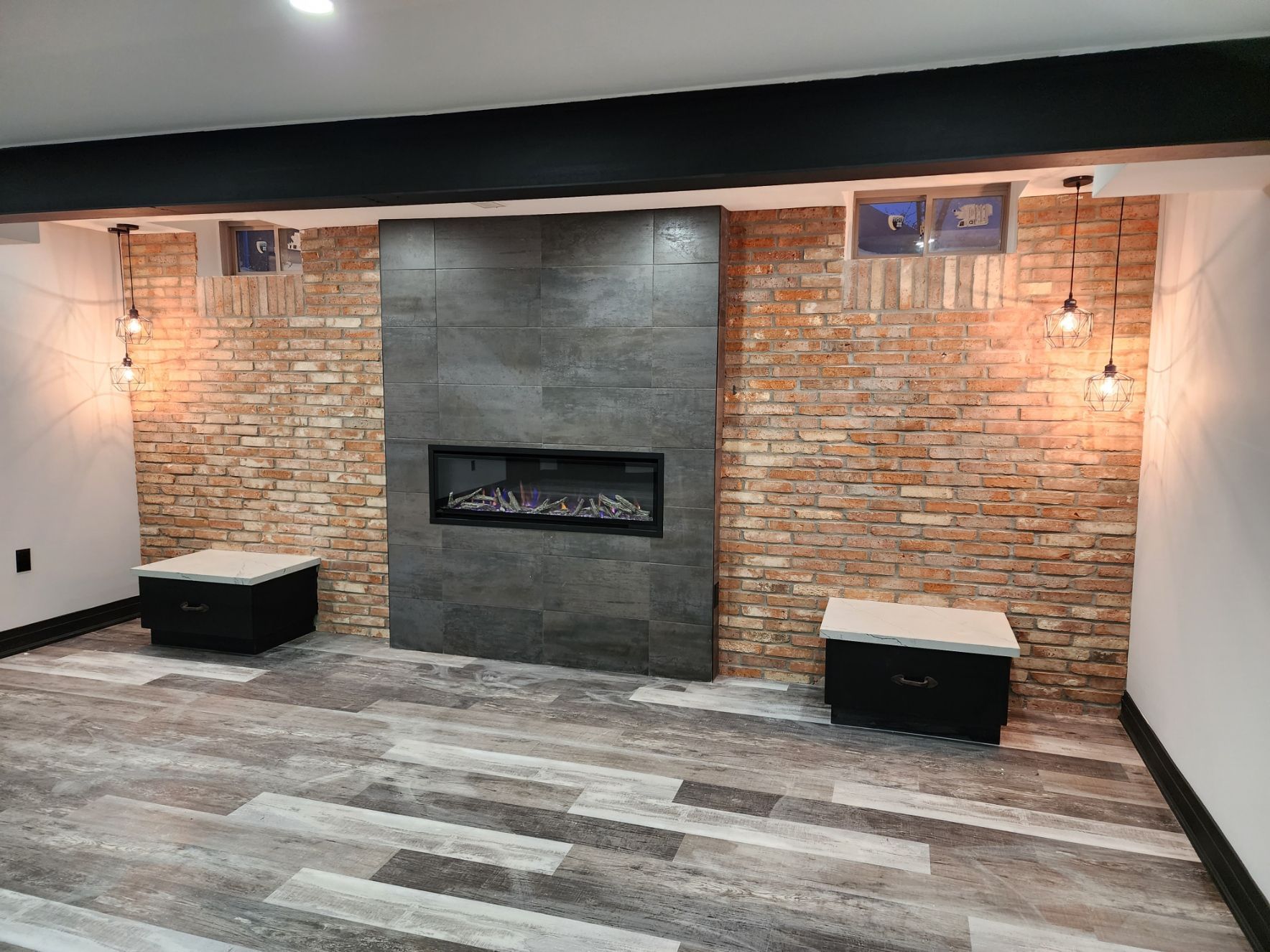 A living room with a fireplace and a brick wall.